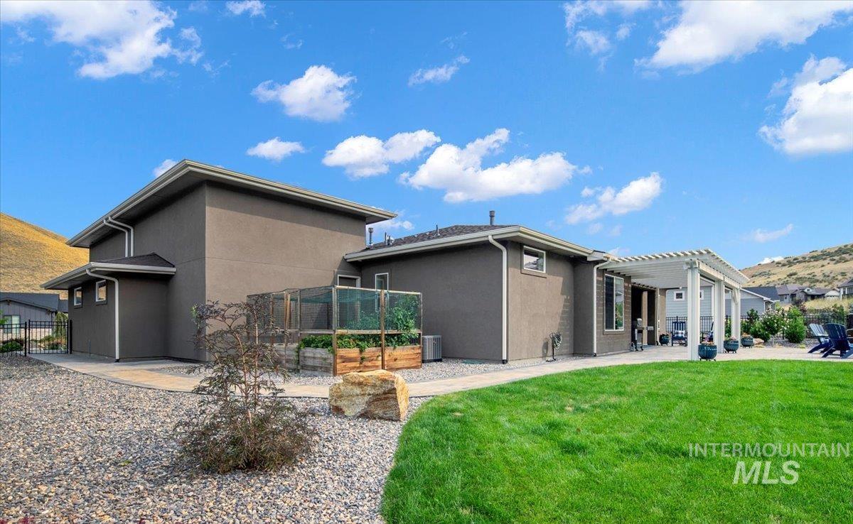Back of house with stucco siding, a pergola, and a patio