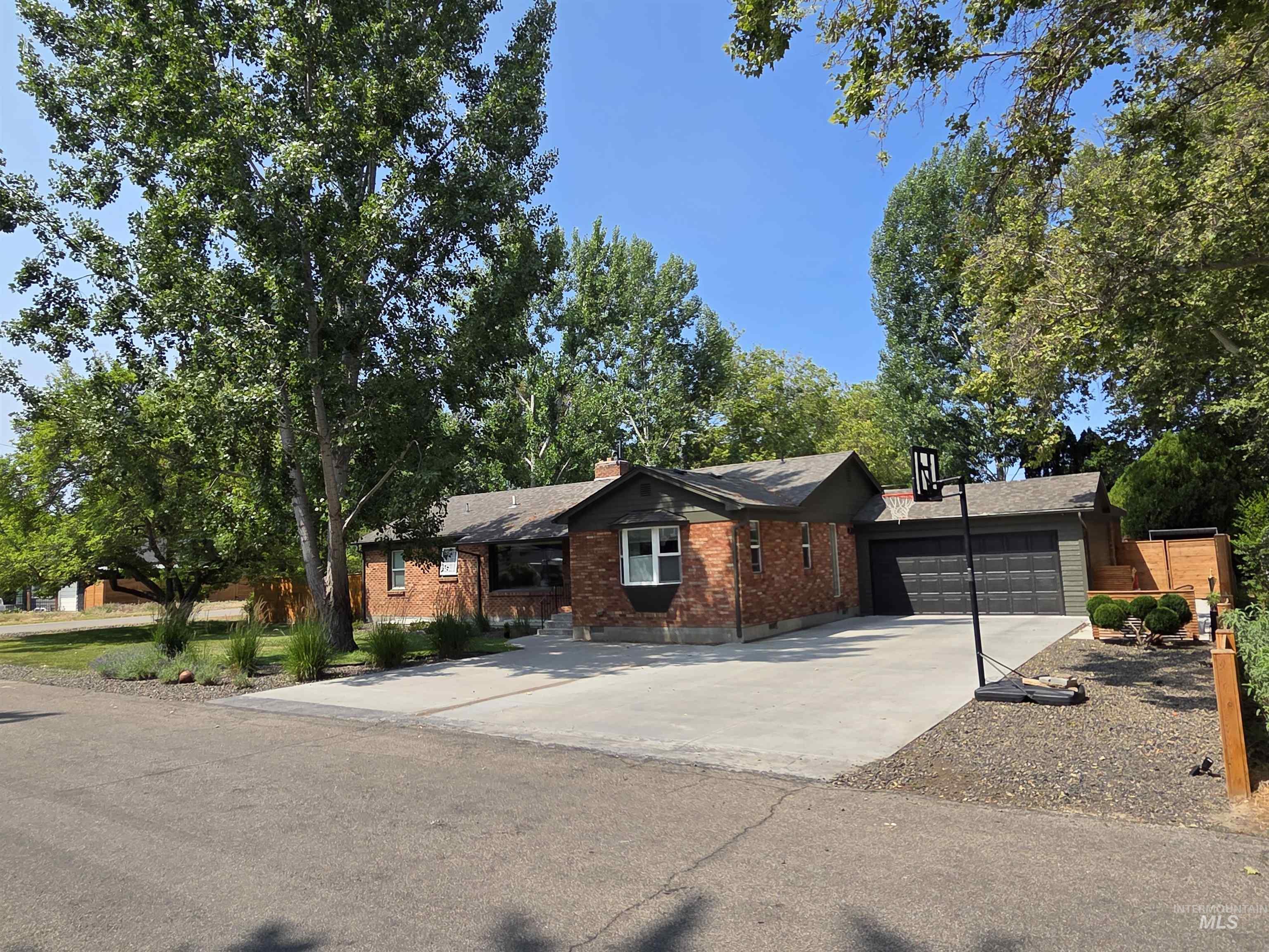 Ranch-style house featuring driveway, an attached garage, and brick siding