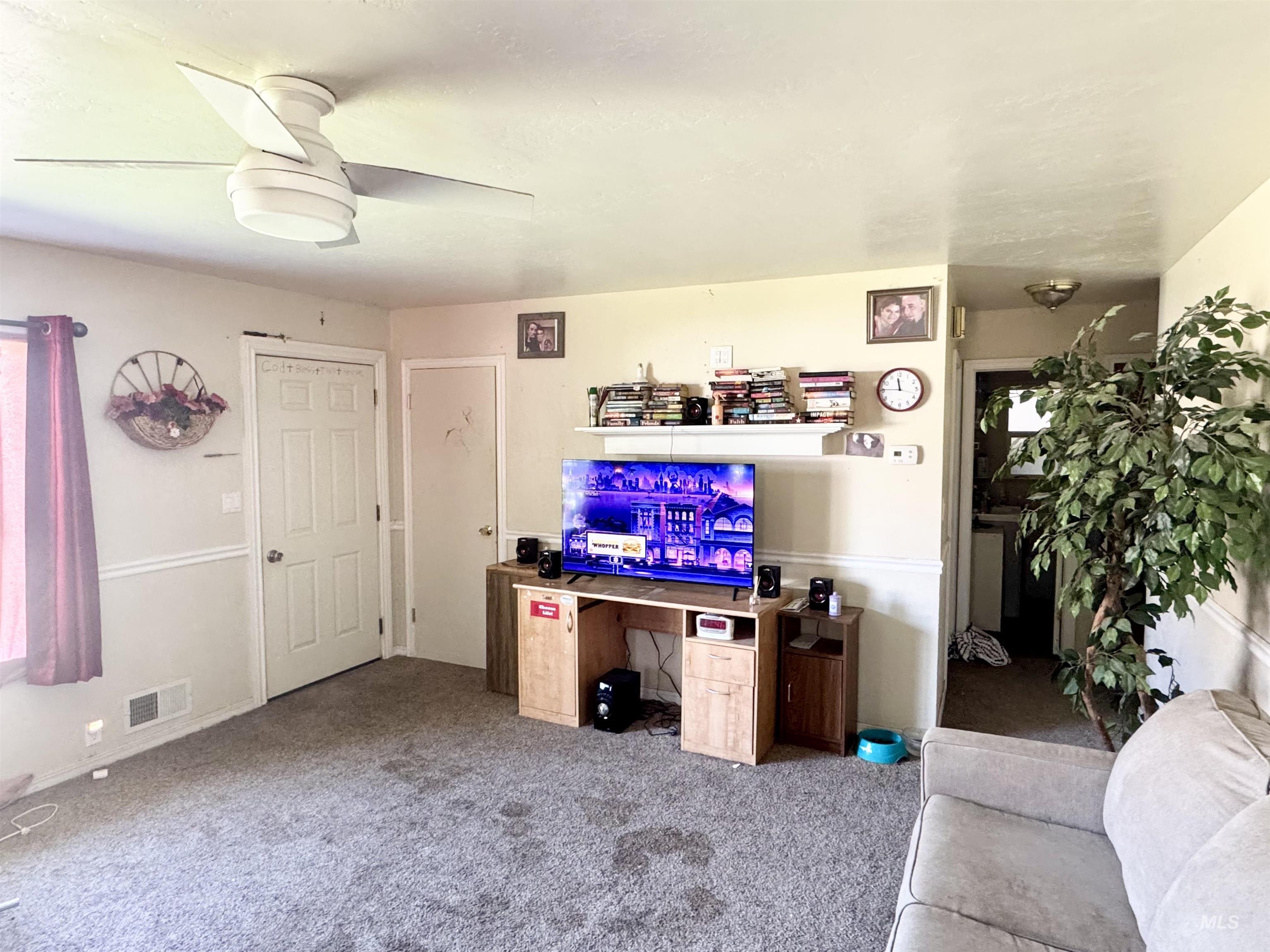Living area with carpet and ceiling fan