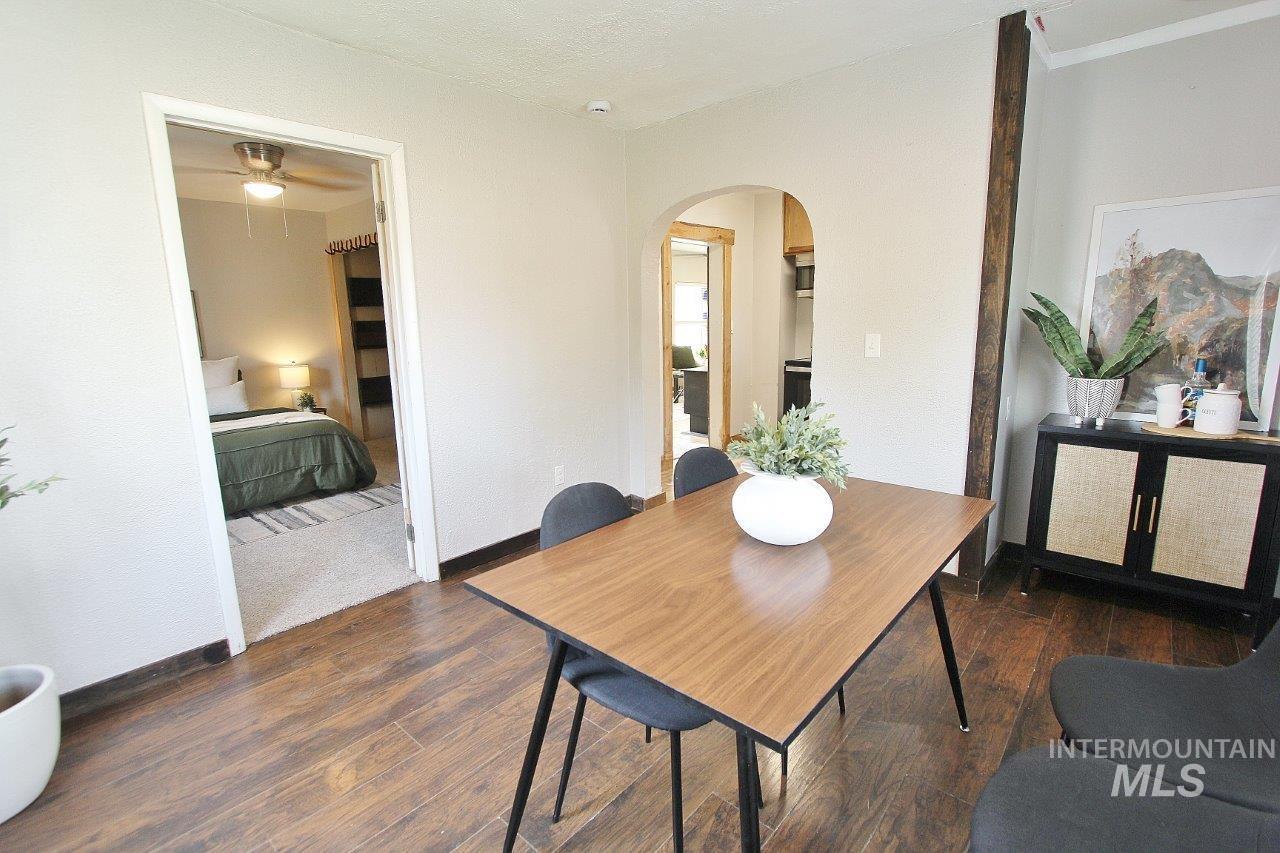 Dining area with dark wood-style floors and arched walkways