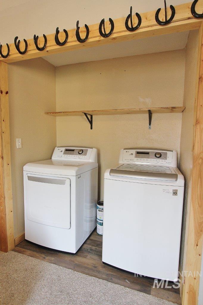 Laundry area featuring dark wood-type flooring and separate washer and dryer