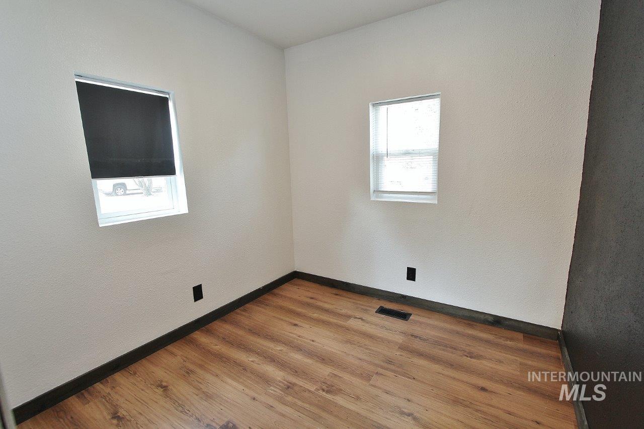 Empty room with wood finished floors and a textured wall