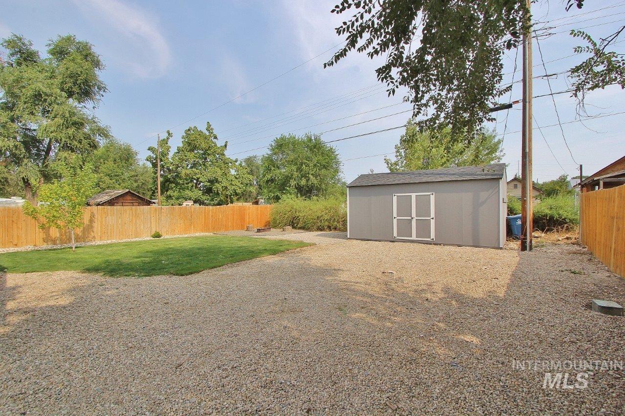 Fenced backyard featuring a storage shed