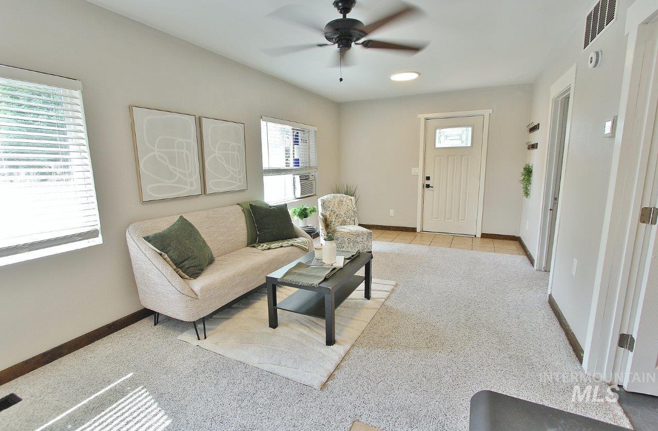 Living area featuring light carpet and ceiling fan