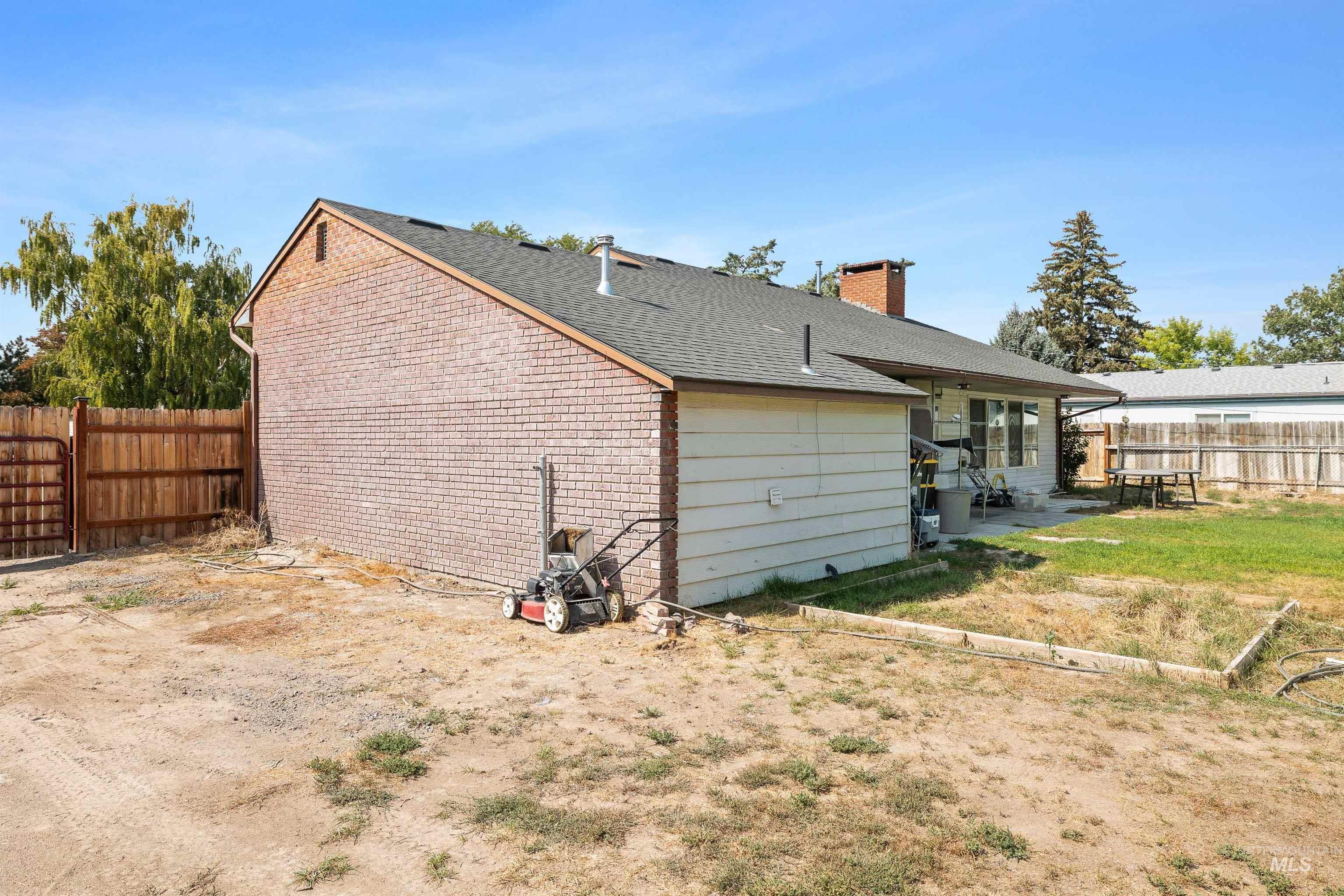 Rear view of house featuring a fenced backyard, roof with shingles, a chimney, and a patio area
