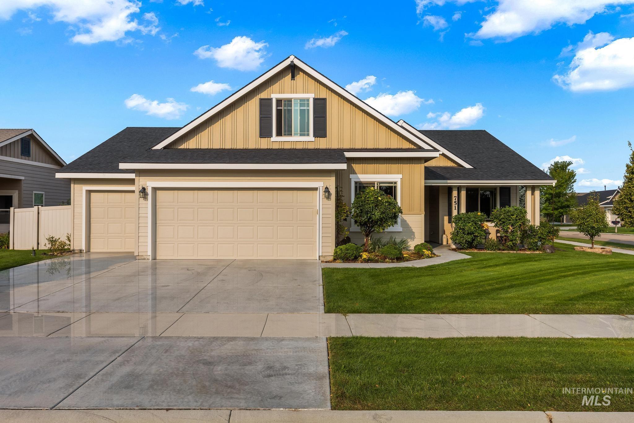 Craftsman-style home featuring roof with shingles, concrete driveway, a front yard, and board and batten siding