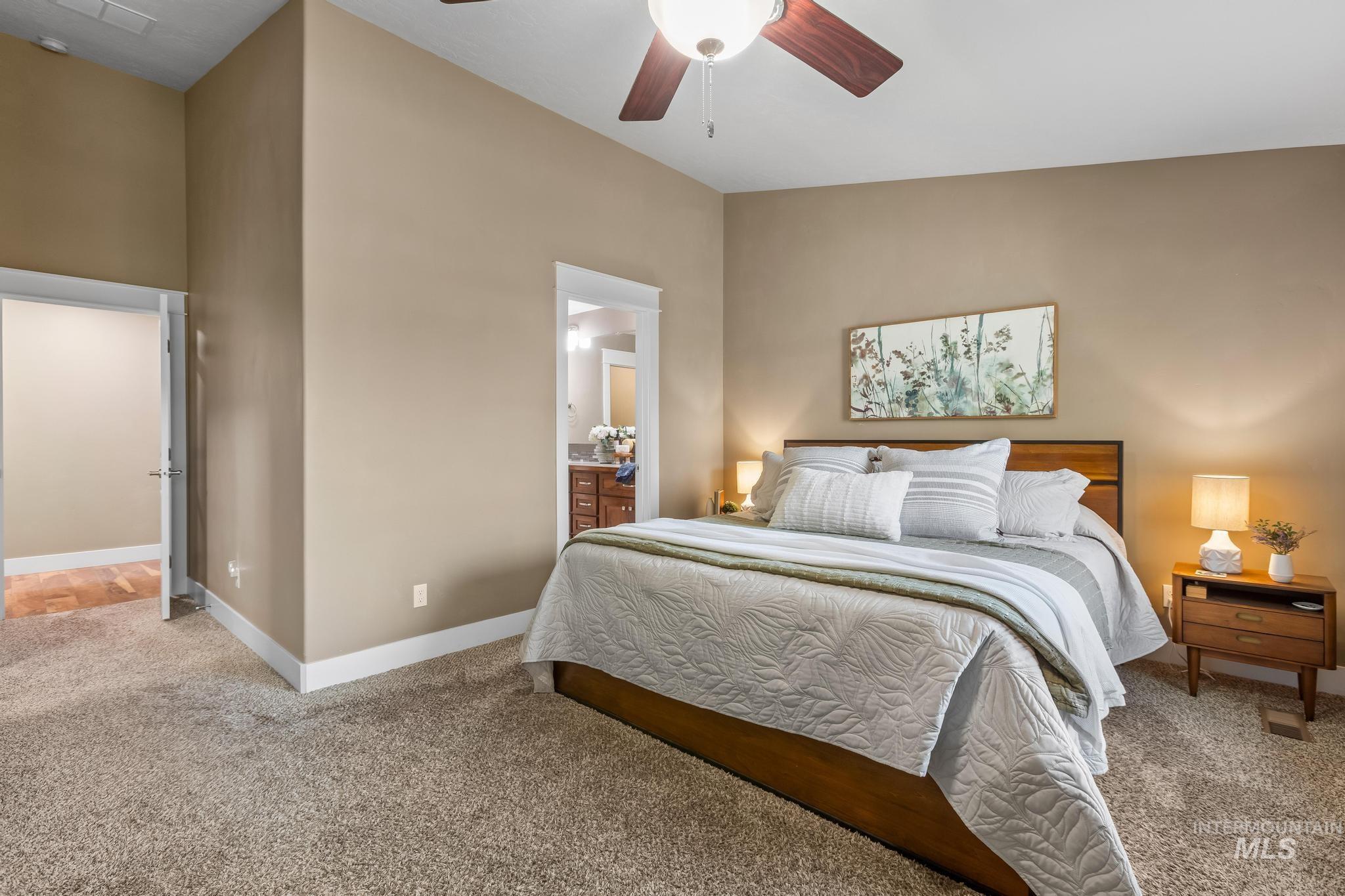 Bedroom with carpet flooring, ceiling fan, and ensuite bath