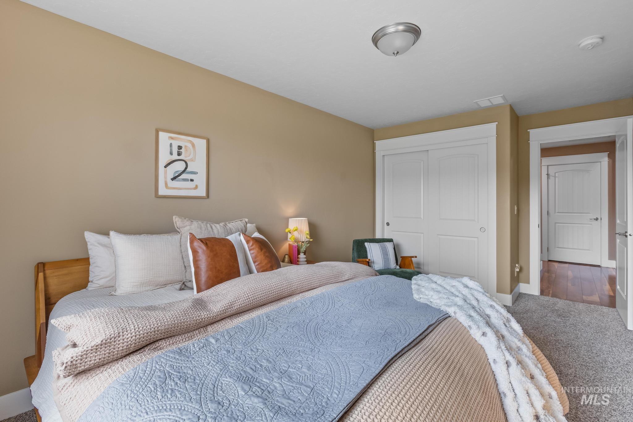 Carpeted bedroom with a closet and baseboards