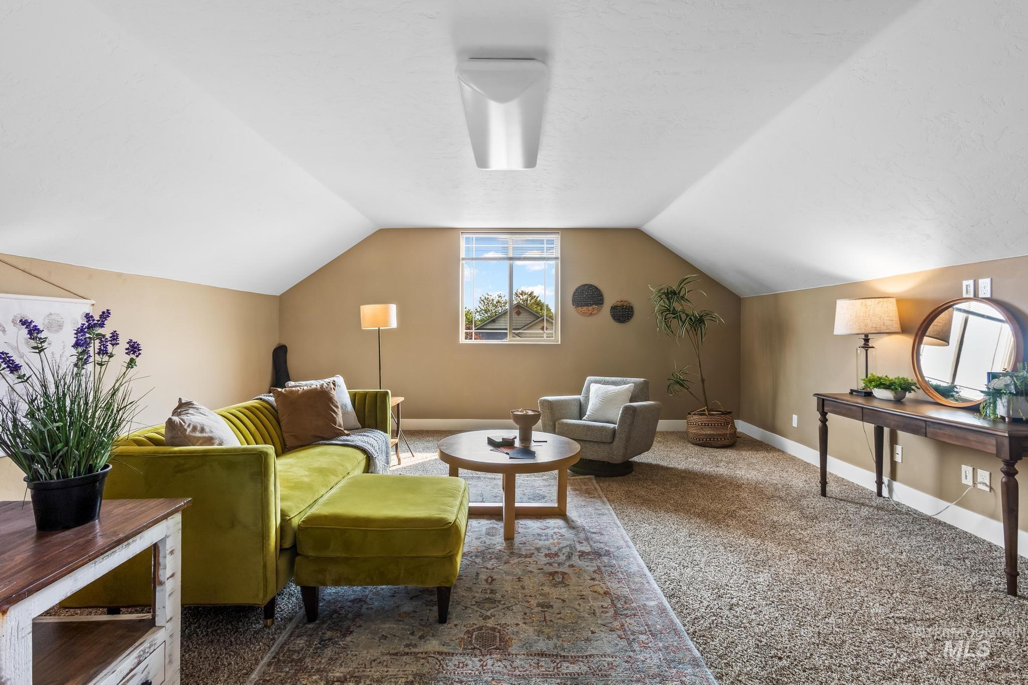 Sitting room with carpet floors and vaulted ceiling
