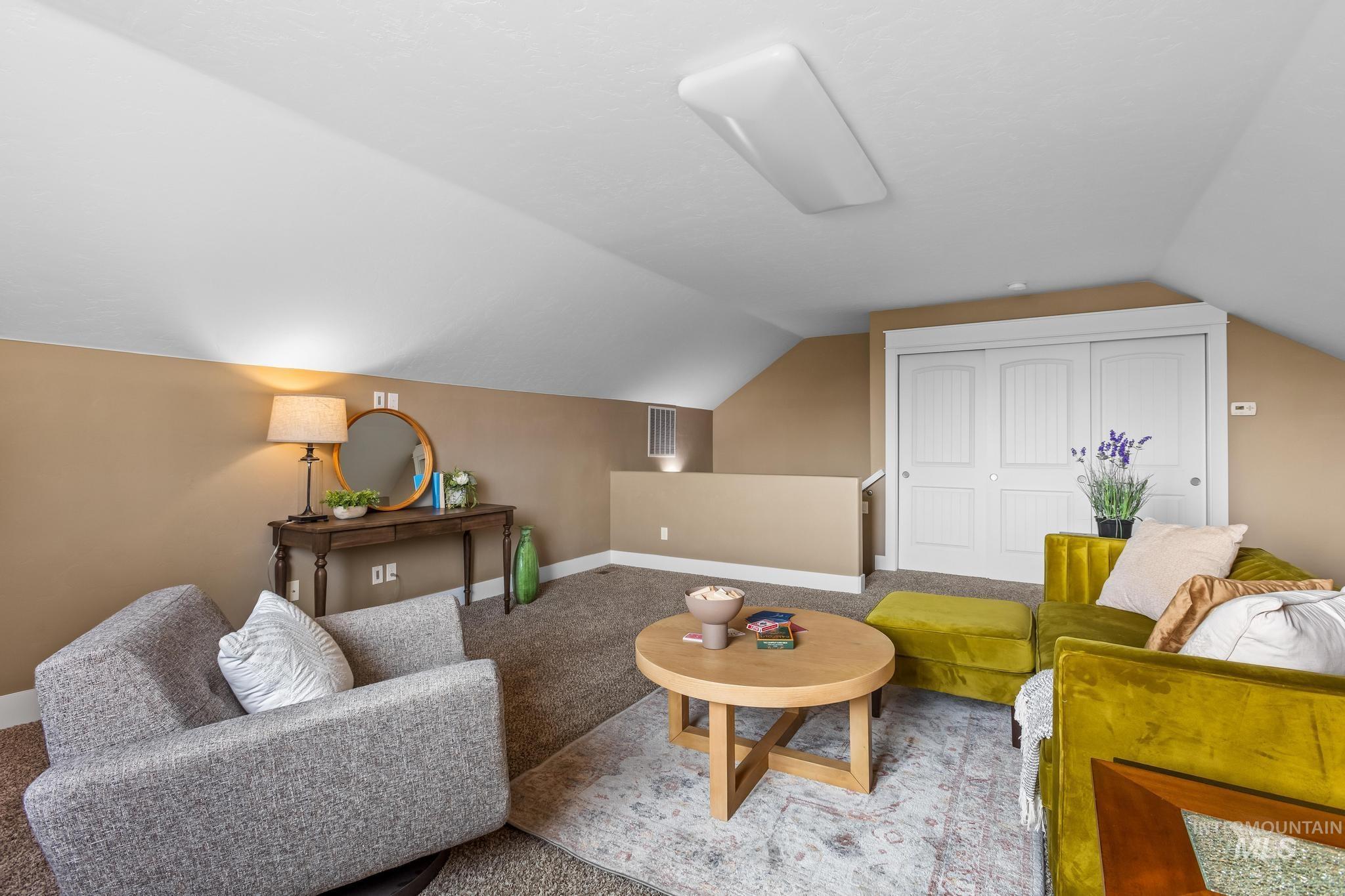 Living area with lofted ceiling and carpet