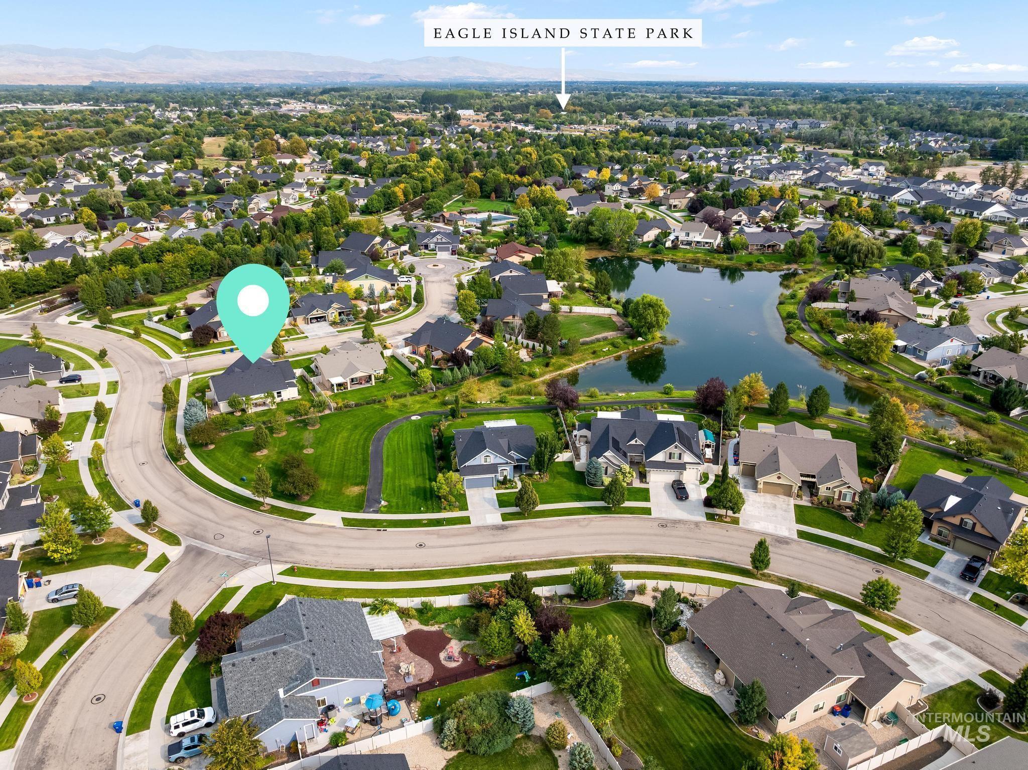 Aerial view of property and surrounding area featuring nearby suburban area and a nearby body of water