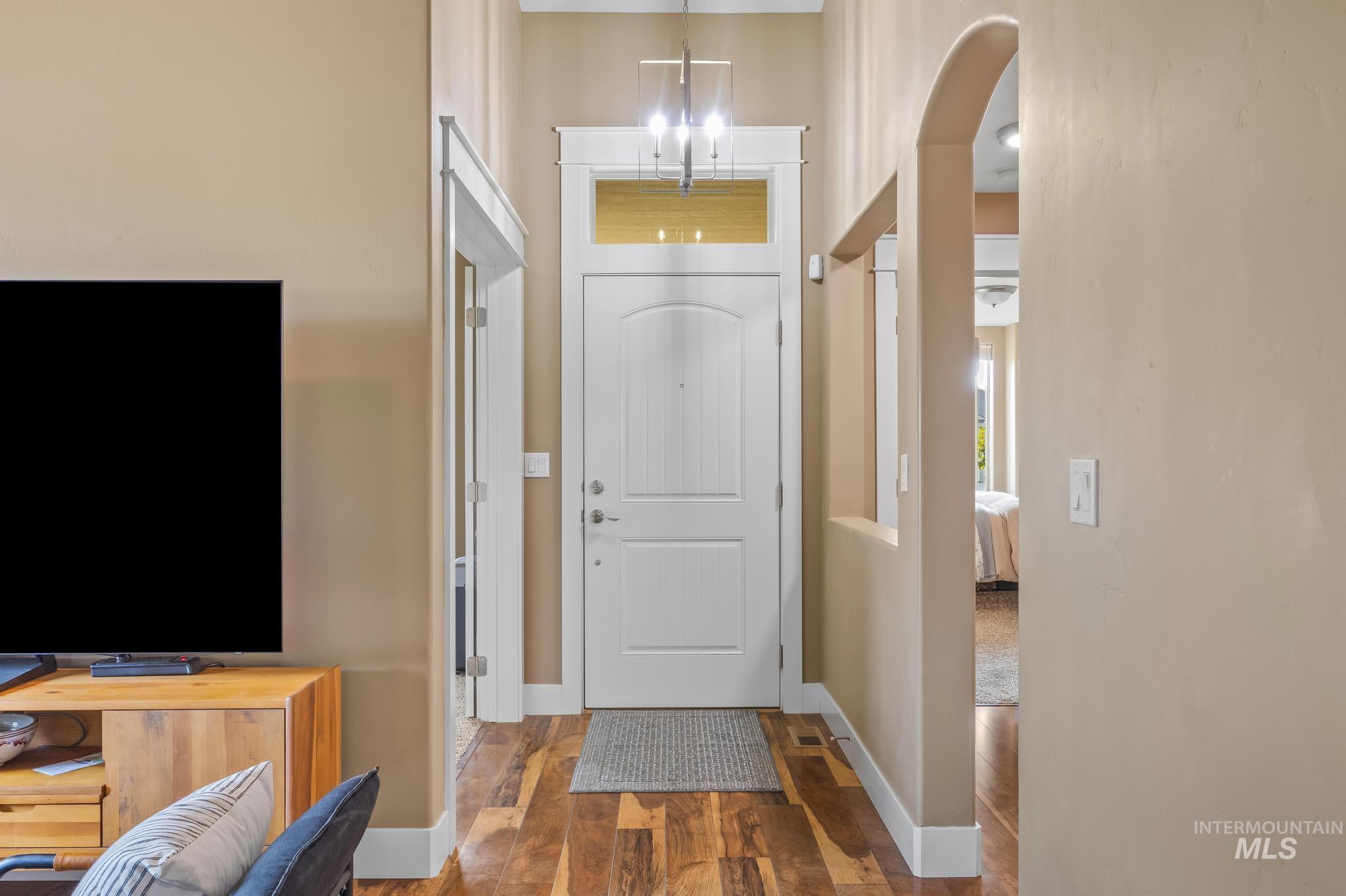 Entrance foyer featuring dark wood-type flooring and arched walkways