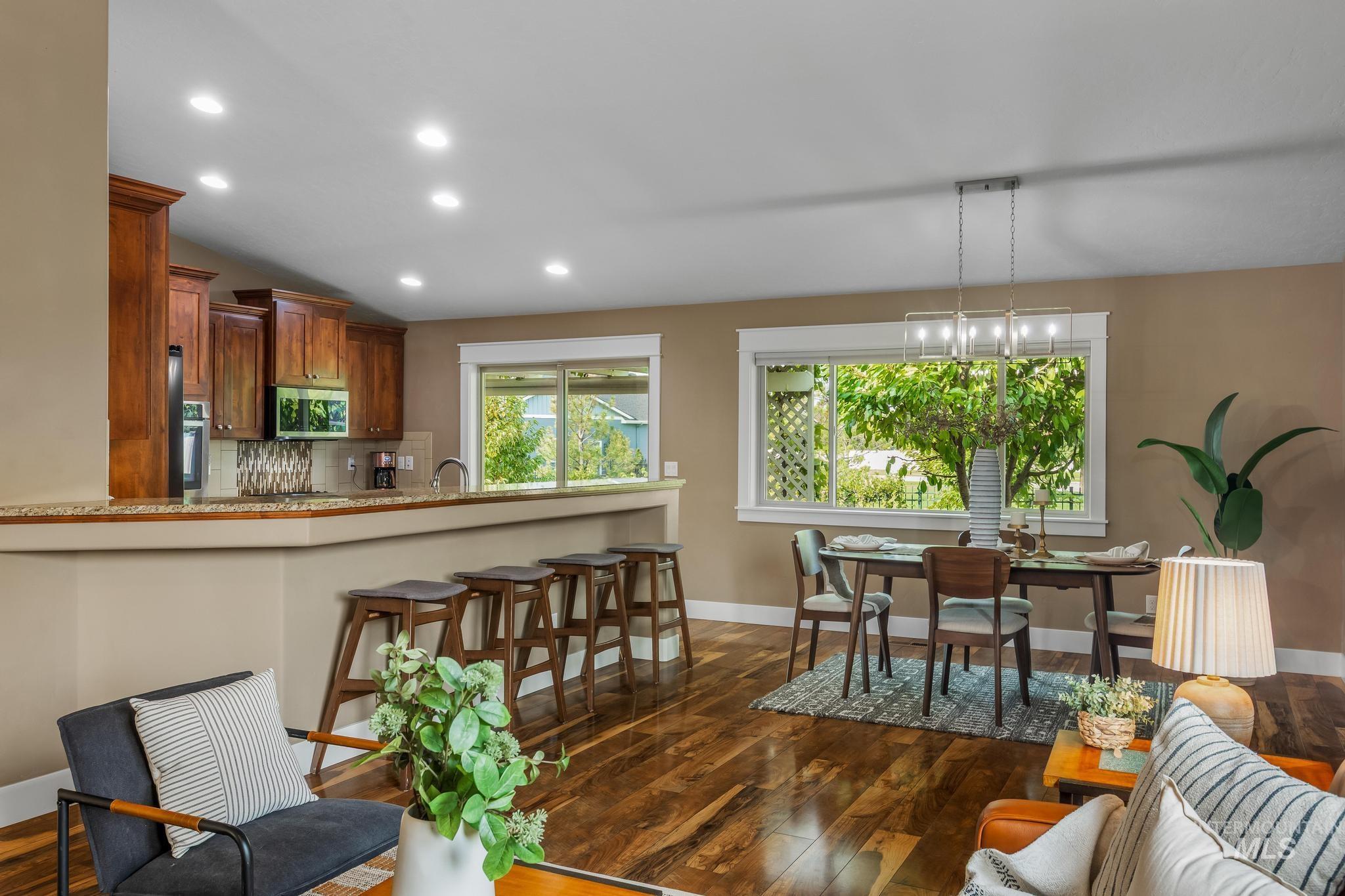 Dining room with dark wood finished floors, recessed lighting, and lofted ceiling
