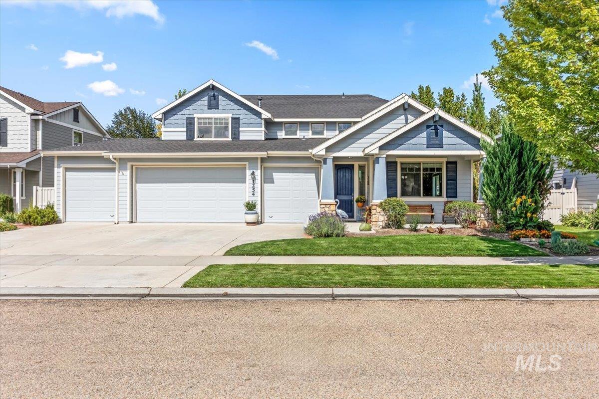 Craftsman-style house featuring concrete driveway, a porch, a front lawn, and stone siding