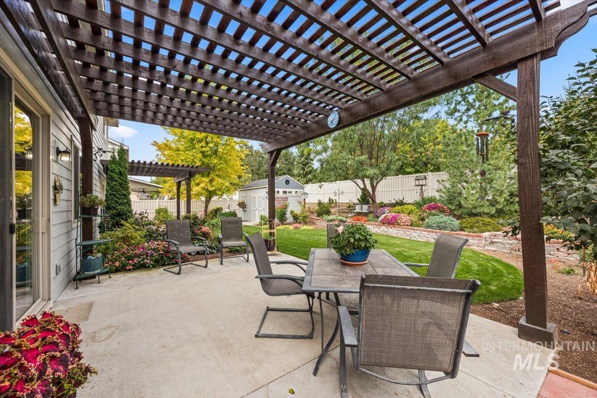 Fenced backyard with a pergola, a patio, and outdoor dining area