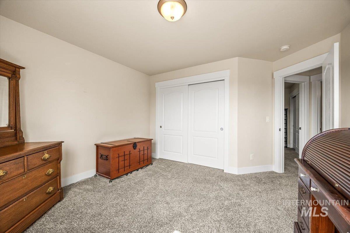 Bedroom with light colored carpet and a closet