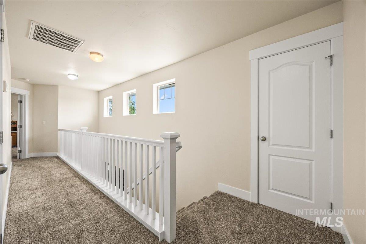 Corridor with carpet and an upstairs landing