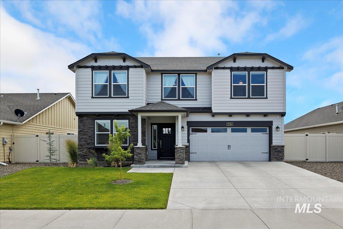 Craftsman inspired home with stone siding, an attached garage, and concrete driveway