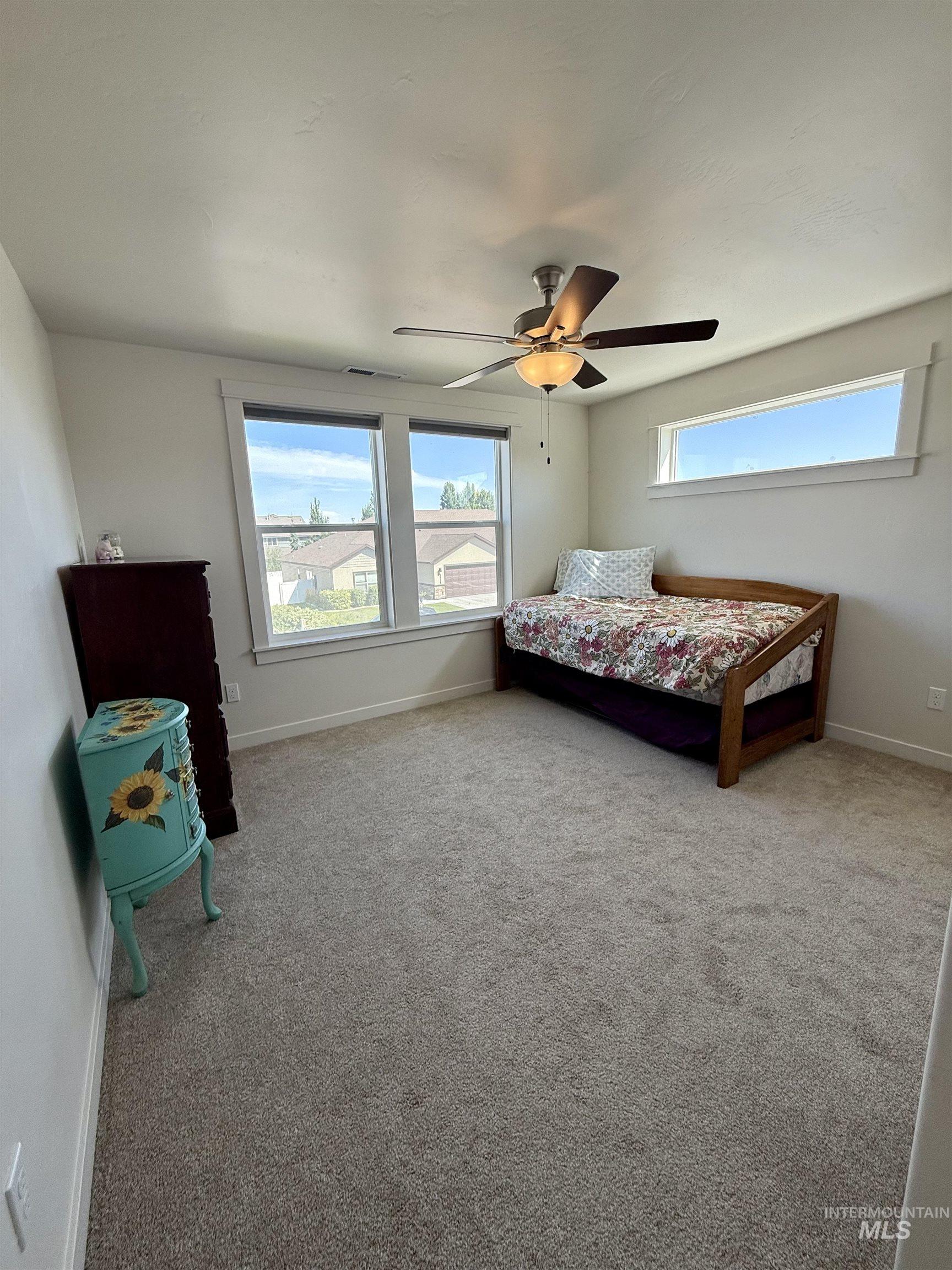 Bedroom featuring light colored carpet and a ceiling fan