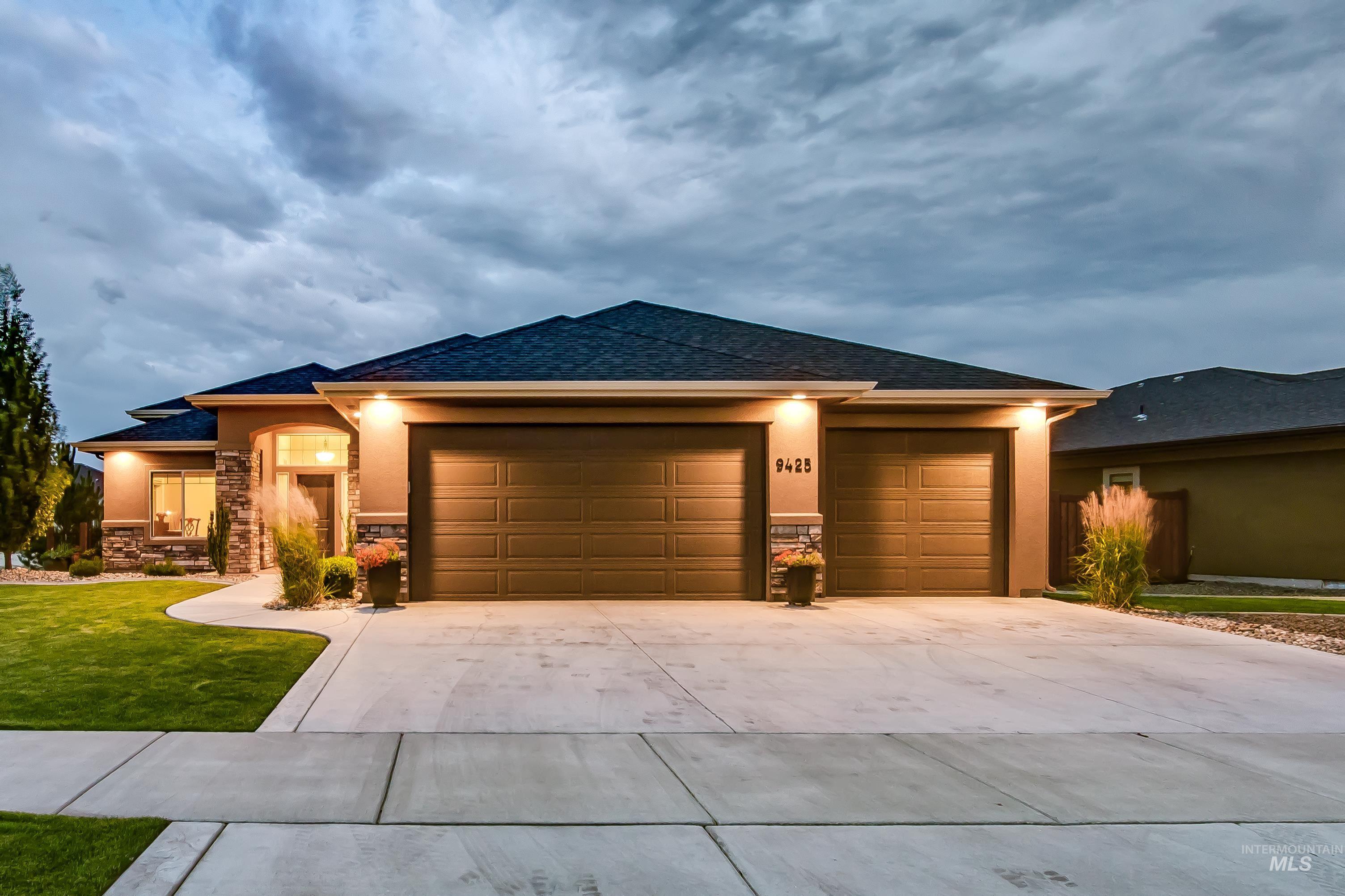 Prairie-style home with stone siding, concrete driveway, an attached garage, stucco siding, and a shingled roof