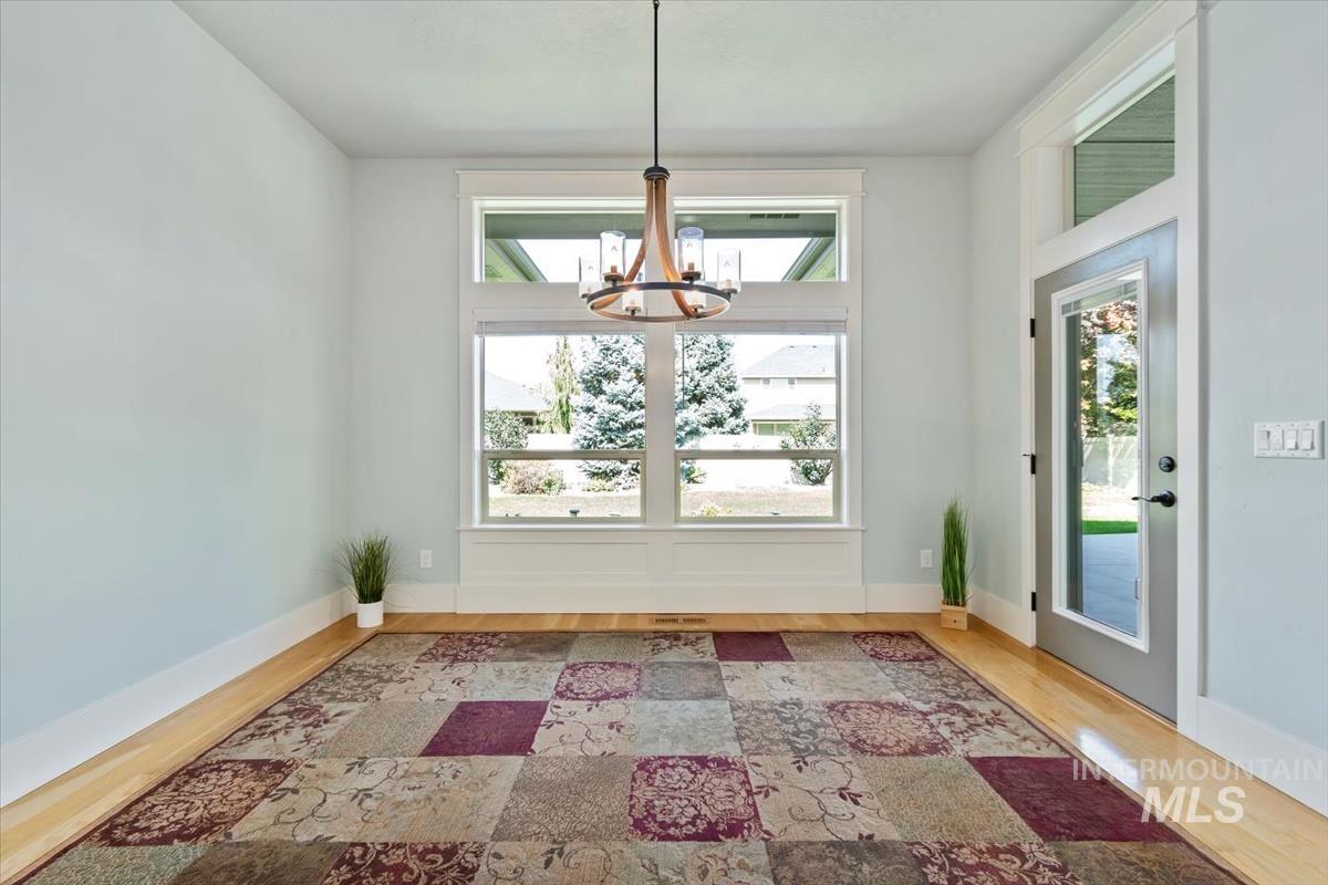 Unfurnished dining area featuring a chandelier and light wood-type flooring
