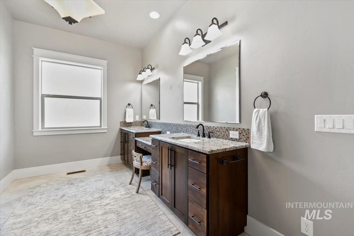 Full bathroom with two vanities, backsplash, healthy amount of natural light, and recessed lighting