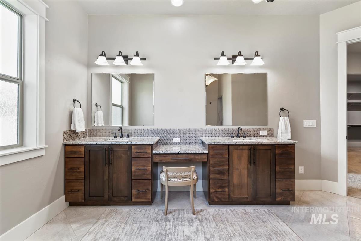 Full bath featuring double vanity and light tile patterned floors