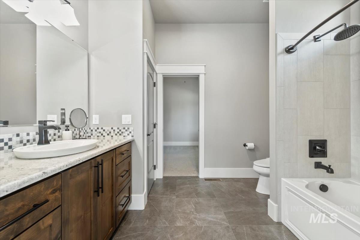 Bathroom with a skylight, vanity, and shower / tub combination