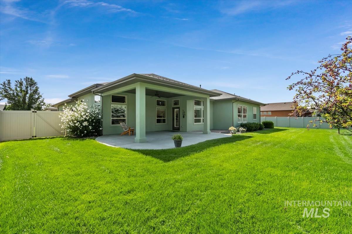 Back of house with ceiling fan, a fenced backyard, a patio area, stucco siding, and a gate
