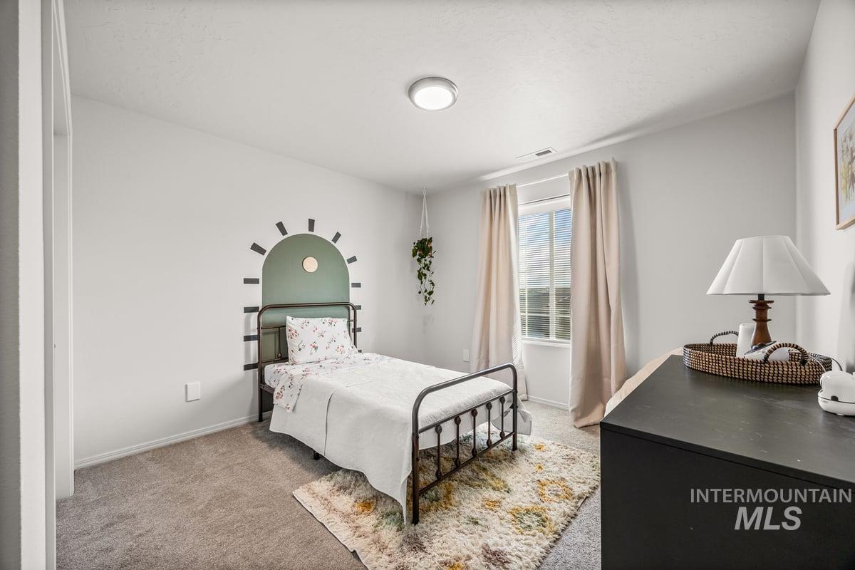 Bedroom with light carpet and baseboards