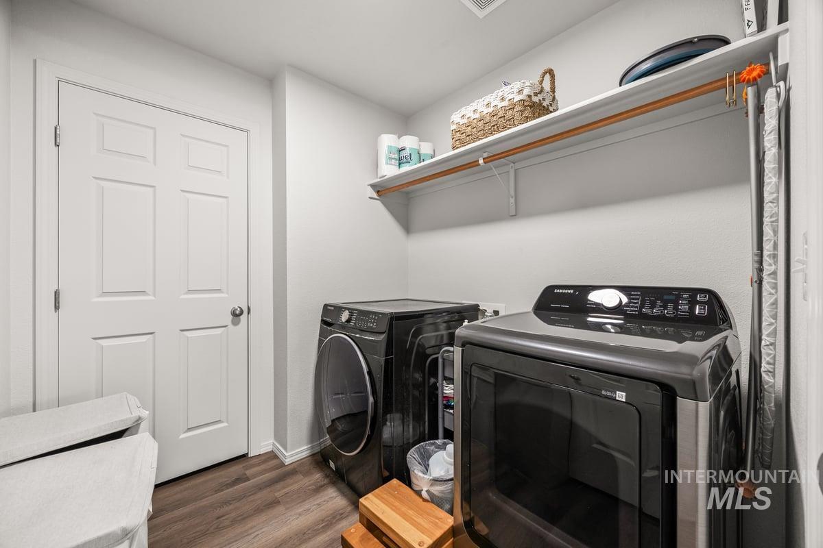 Laundry area featuring dark wood-style floors and washer and clothes dryer