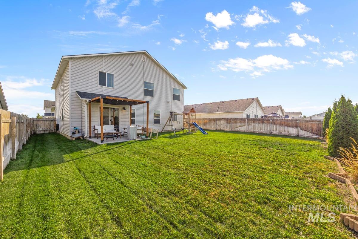 Back of property featuring a patio area, a fenced backyard, and a playground