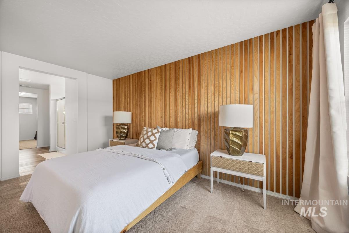 Bedroom featuring wooden walls and carpet floors