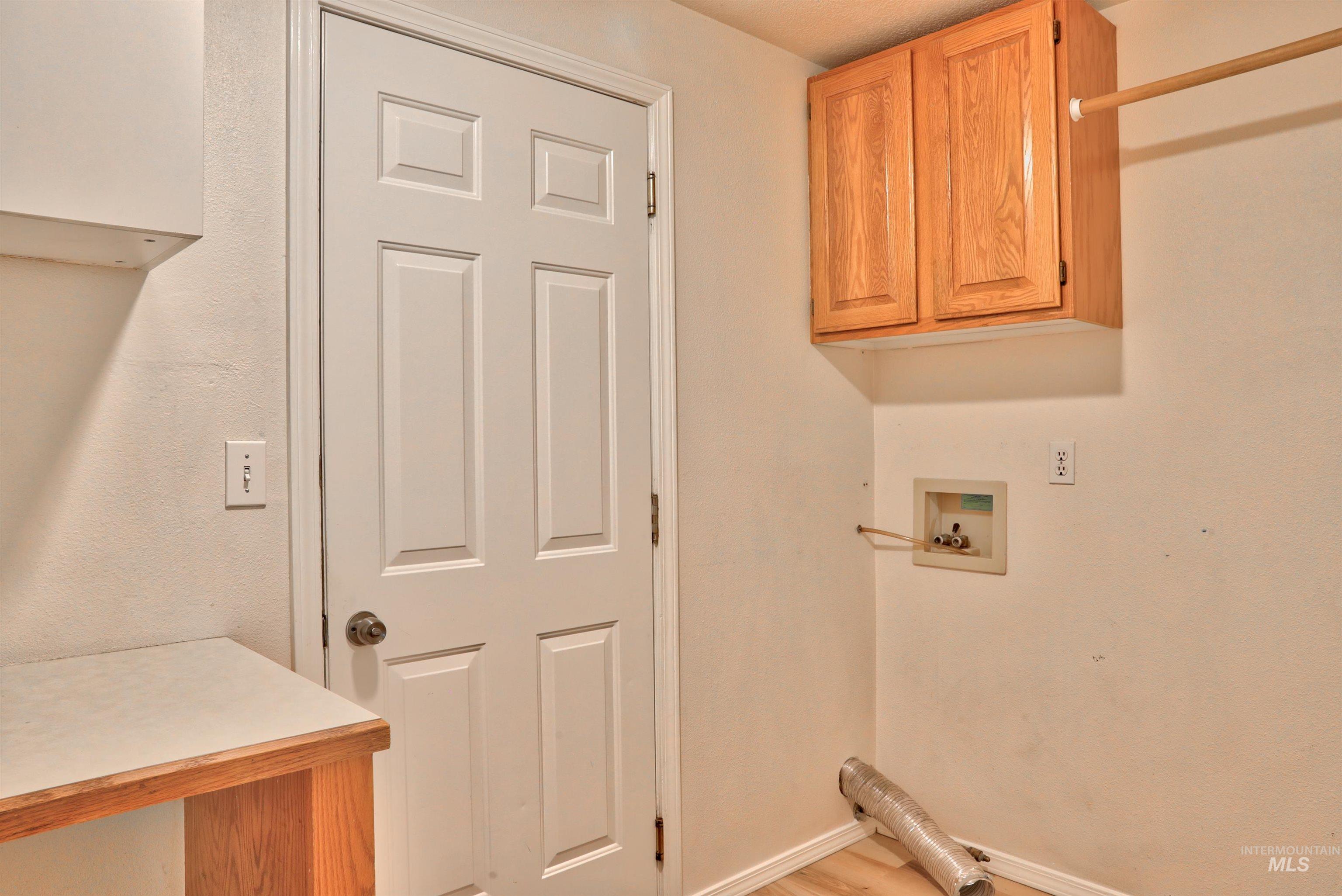 Laundry area featuring cabinet space, washer hookup, and light wood-style floors