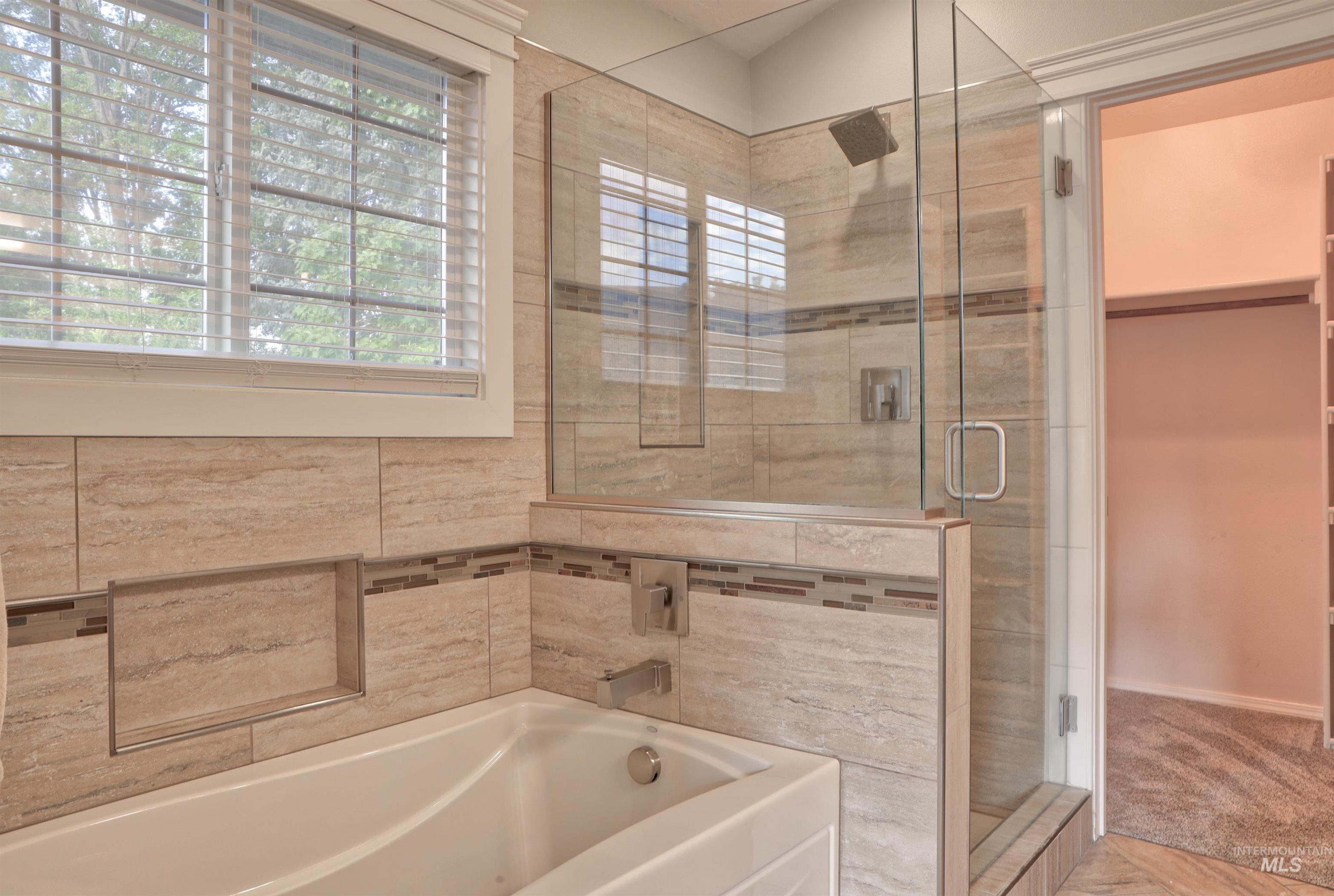 Full bathroom featuring a stall shower and a garden tub