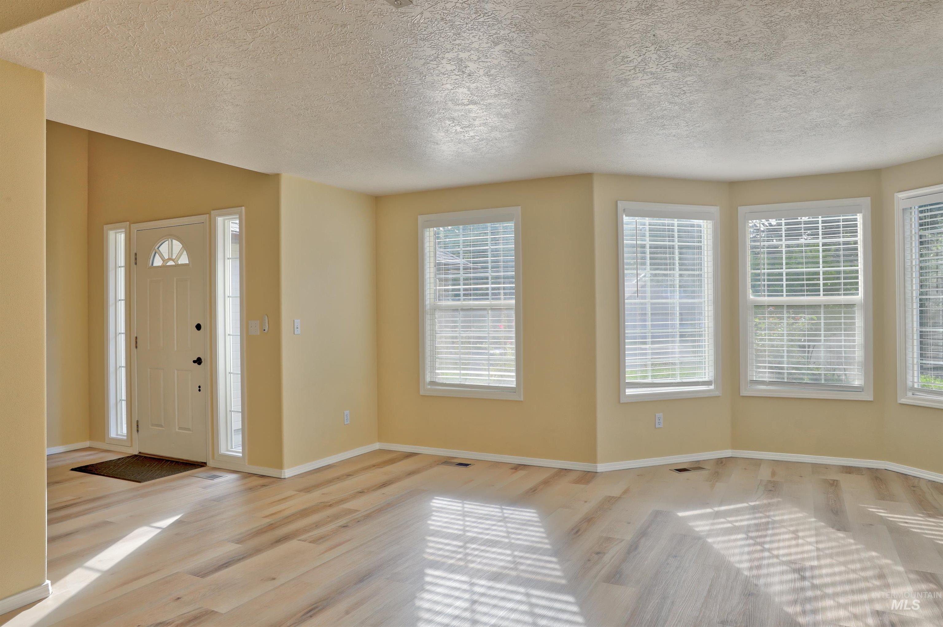 Foyer entrance featuring wood finished floors and a textured ceiling