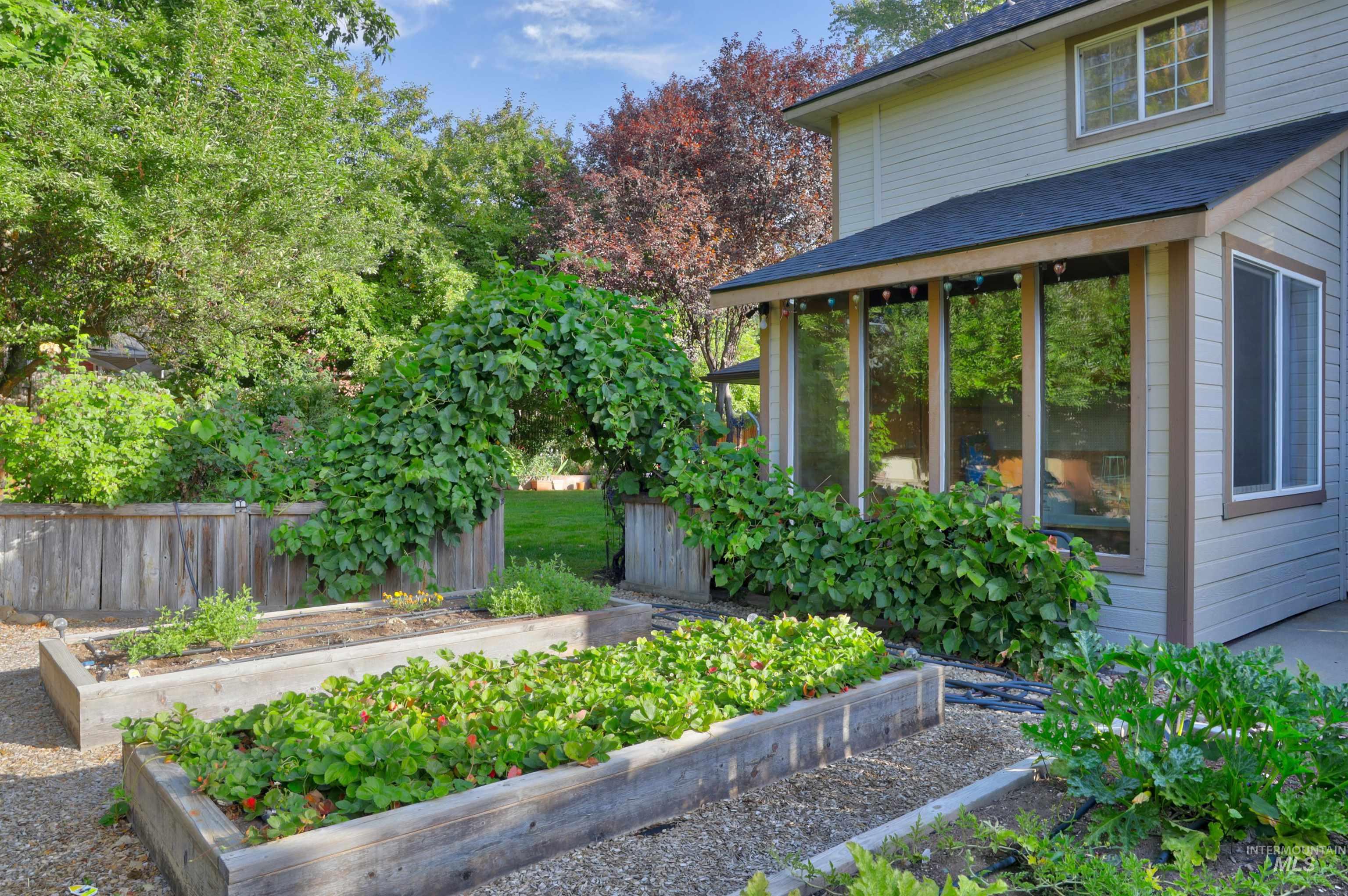 View of yard with a vegetable garden and a sunroom