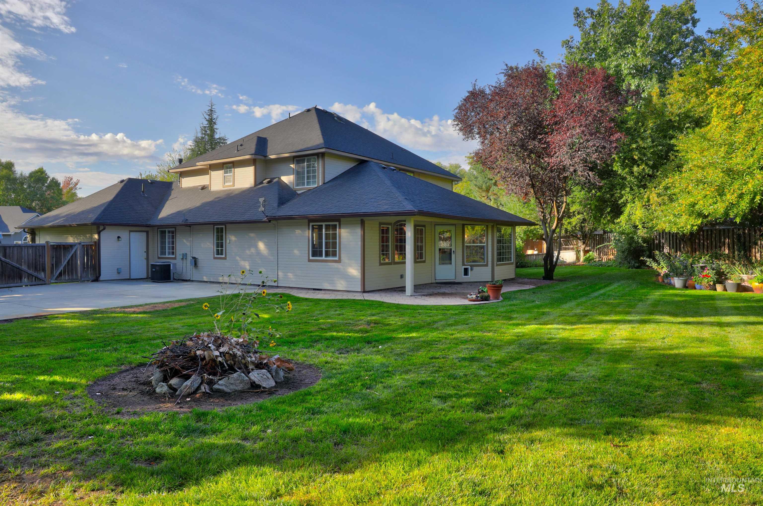 Back of property with a fenced backyard, a patio area, and an outdoor fire pit