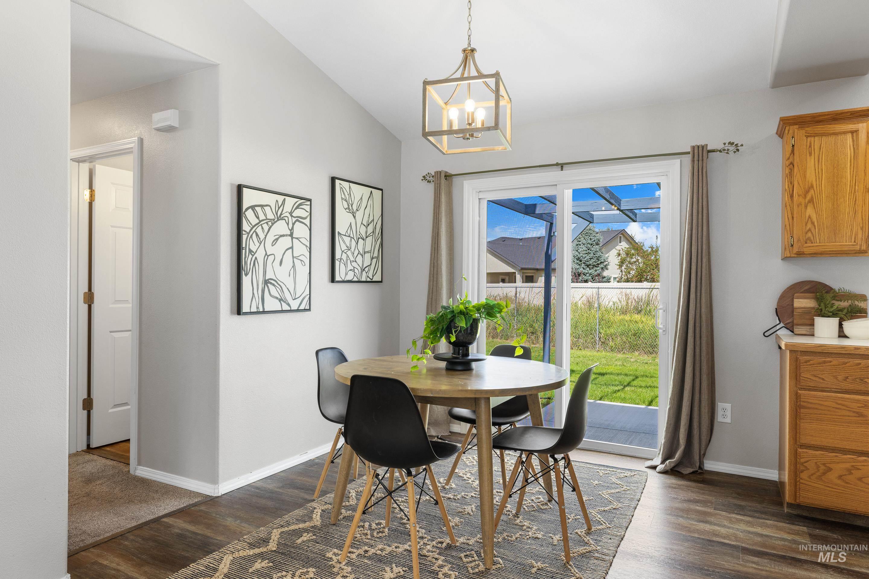 Dining area featuring dark wood-type flooring and a chandelier