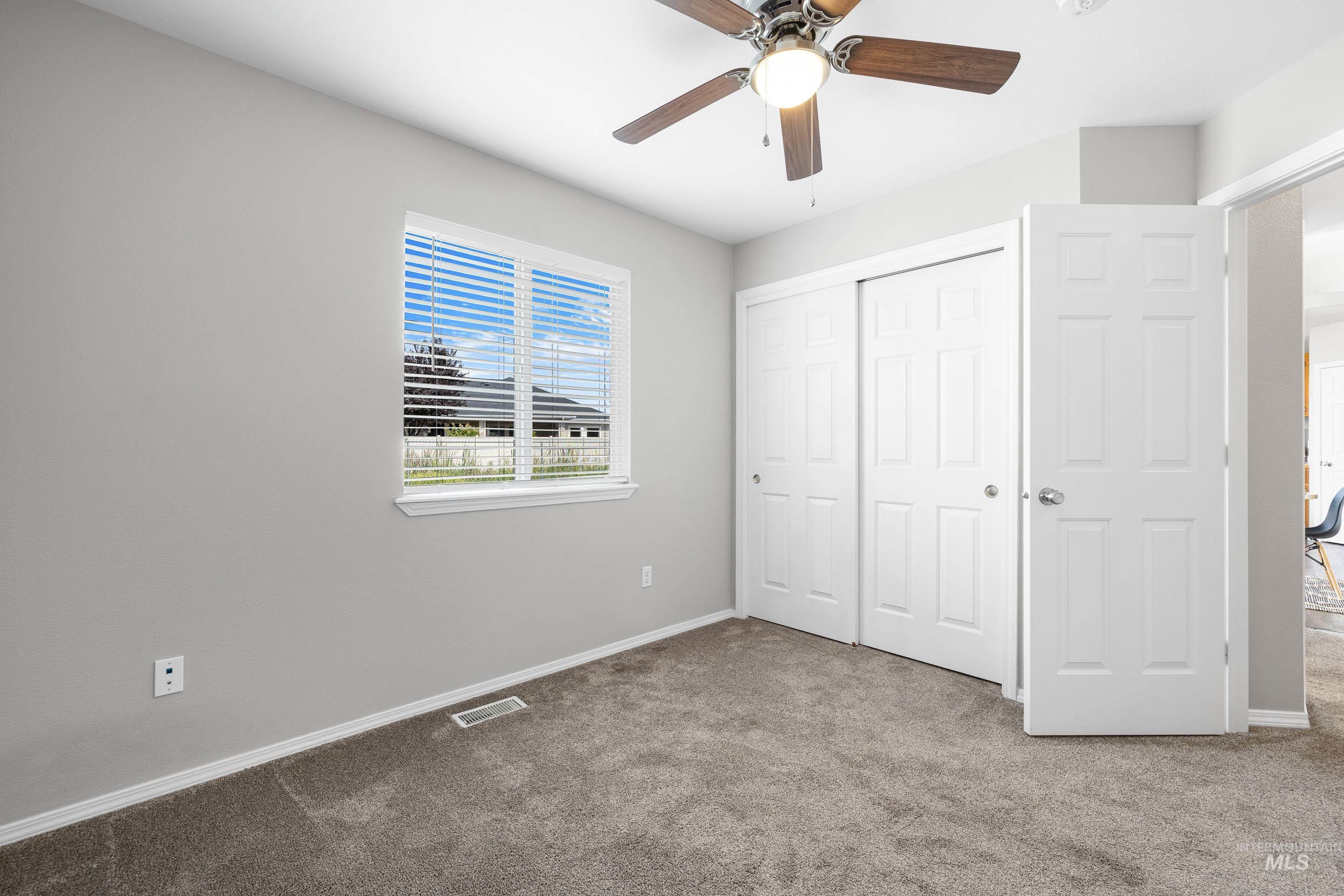 Unfurnished bedroom featuring carpet, a closet, and ceiling fan