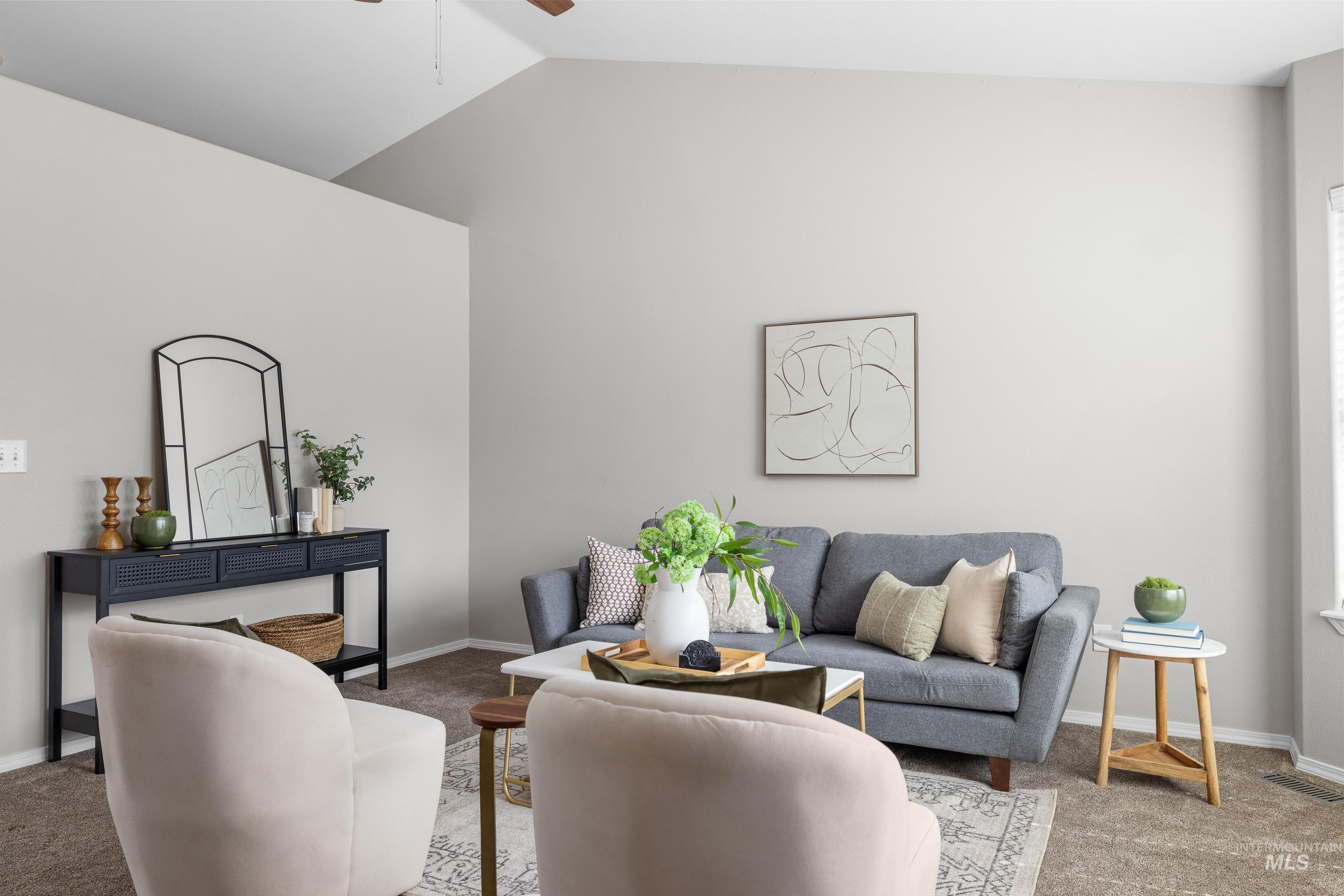 Carpeted living area with lofted ceiling and a ceiling fan