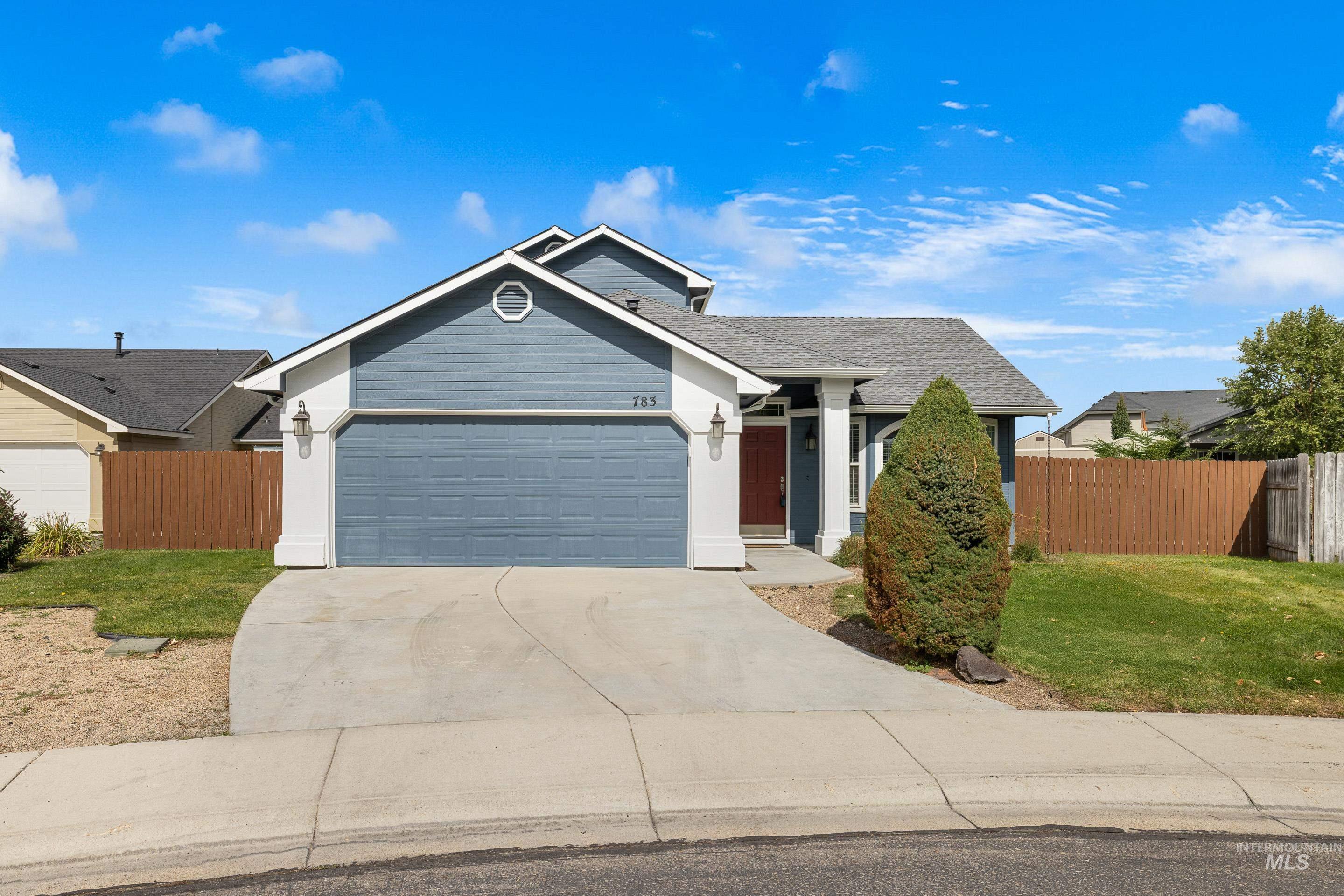 Ranch-style home featuring concrete driveway, a garage, and a shingled roof