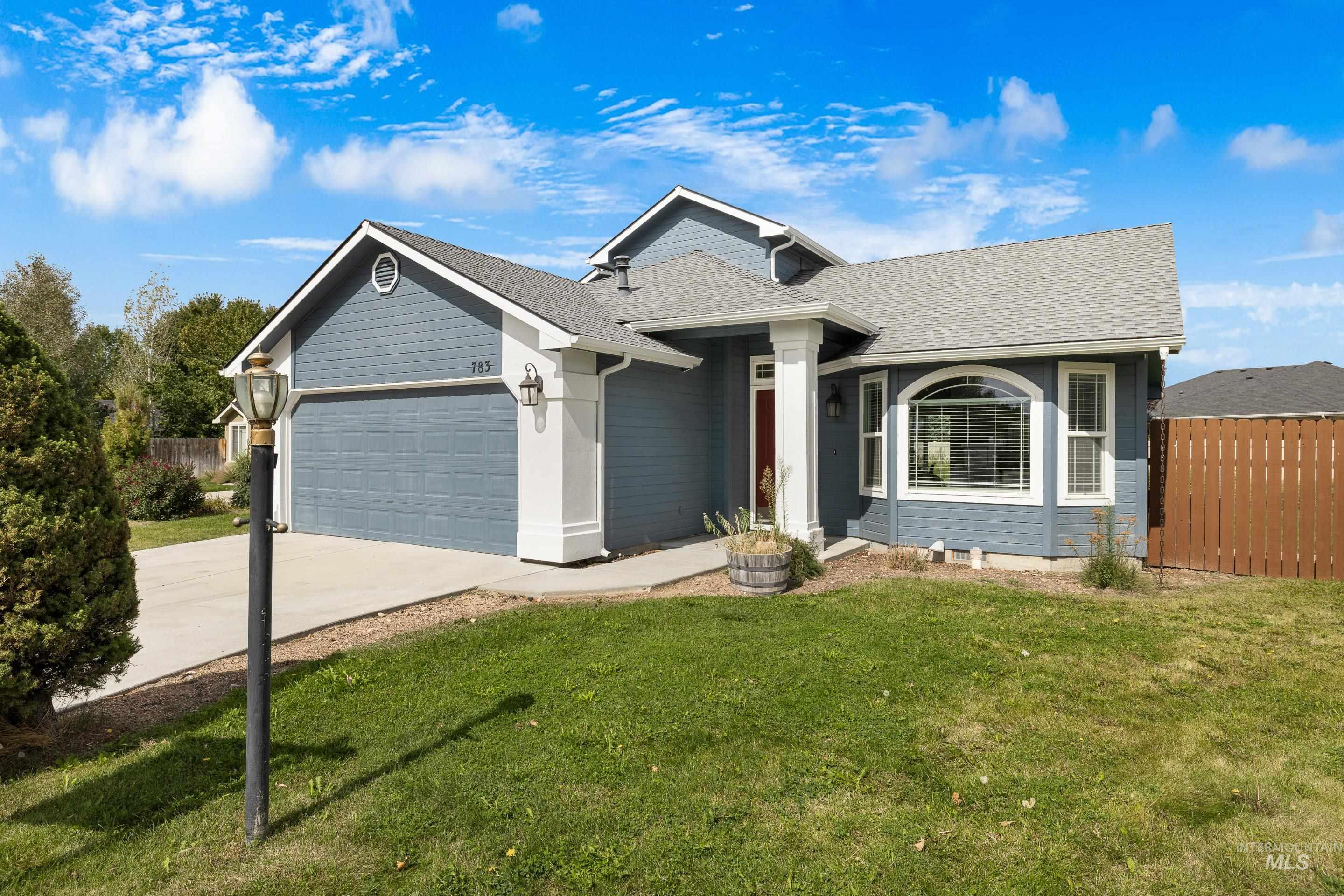 Ranch-style home featuring a shingled roof, driveway, and a garage