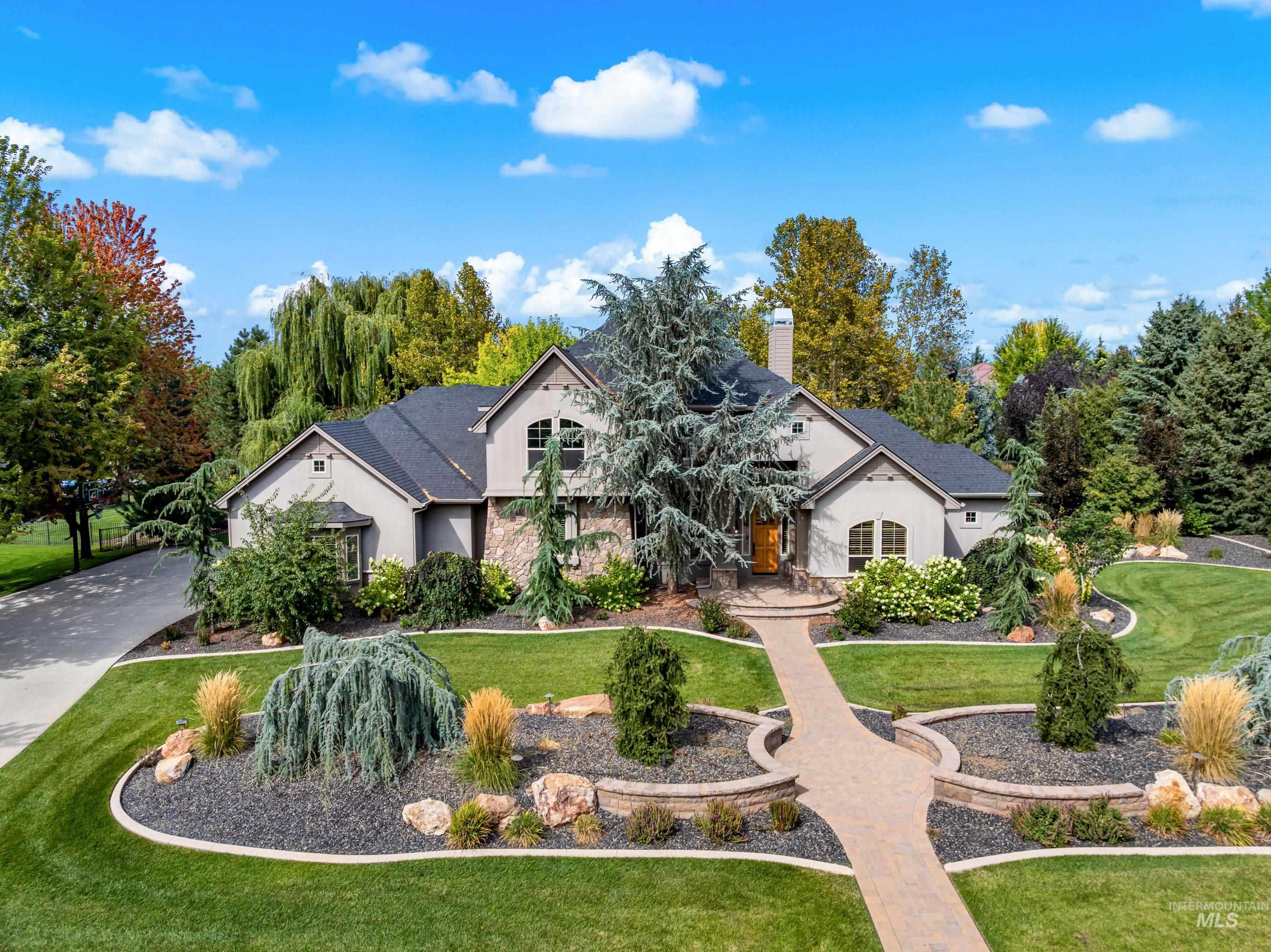 View of front of house with a front lawn, a chimney, stucco siding, and concrete driveway