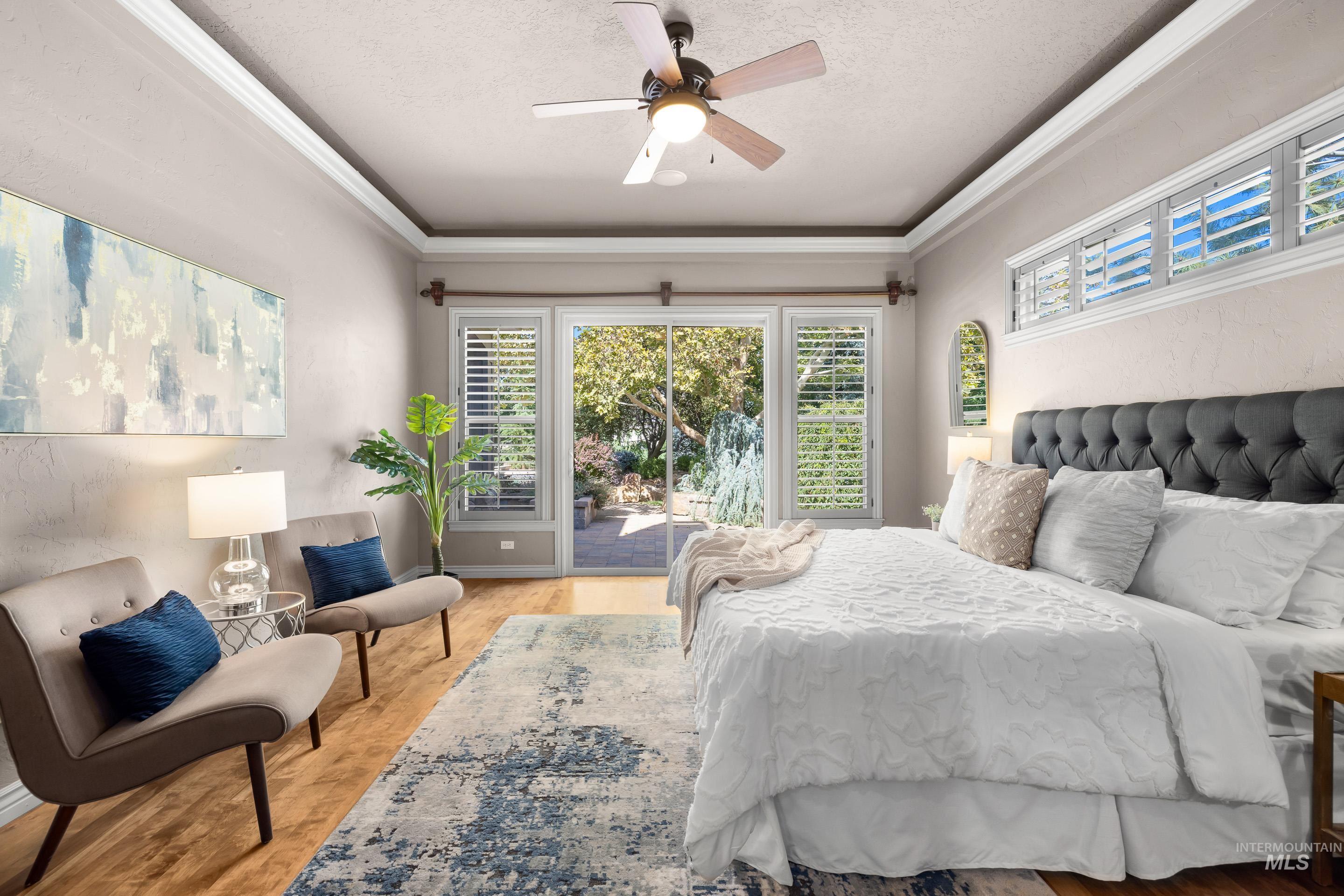 Bedroom featuring a textured ceiling, access to outside, ornamental molding, ceiling fan, and light wood finished floors