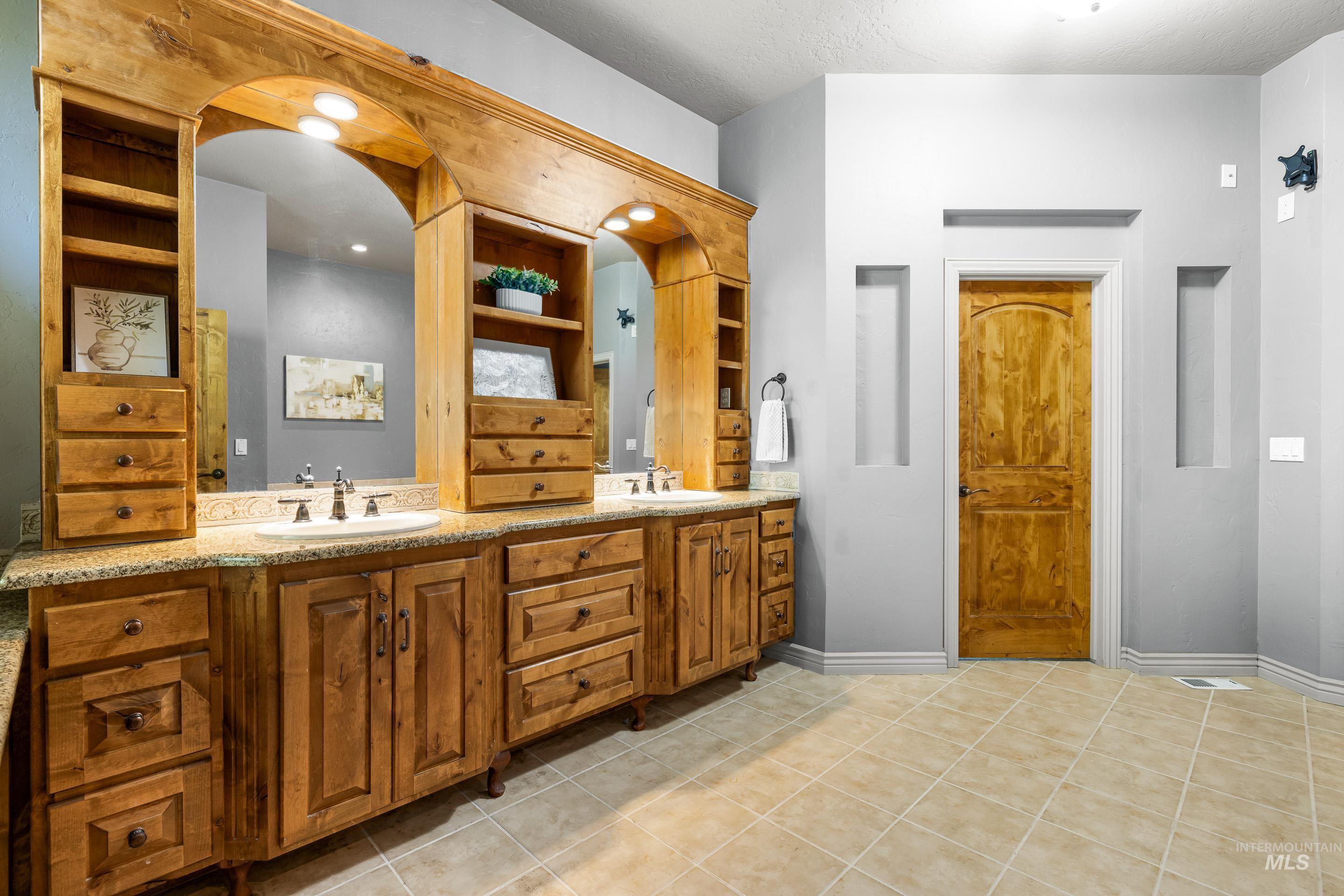 Full bathroom with double vanity and light tile patterned floors