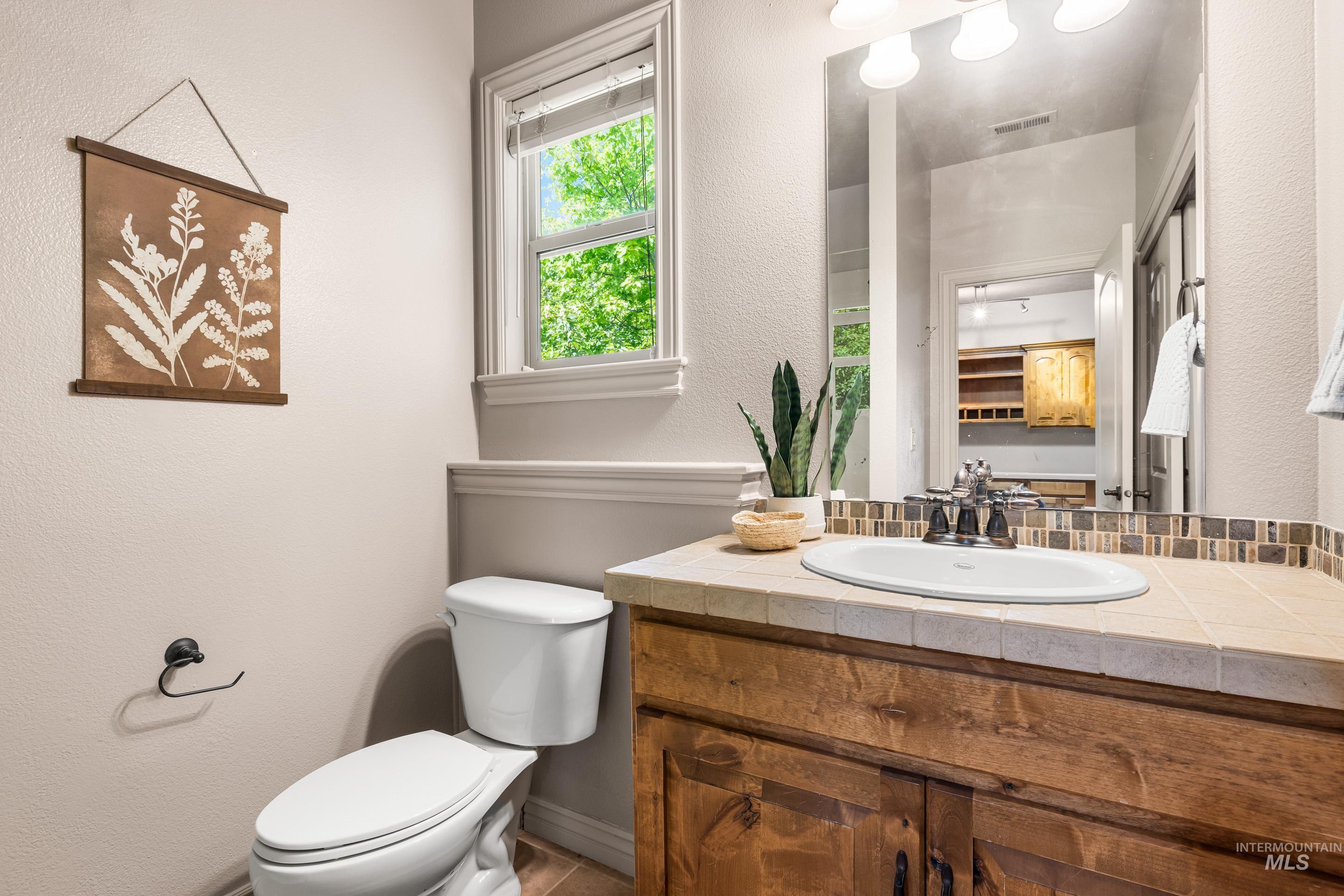 Bathroom with a textured wall and vanity