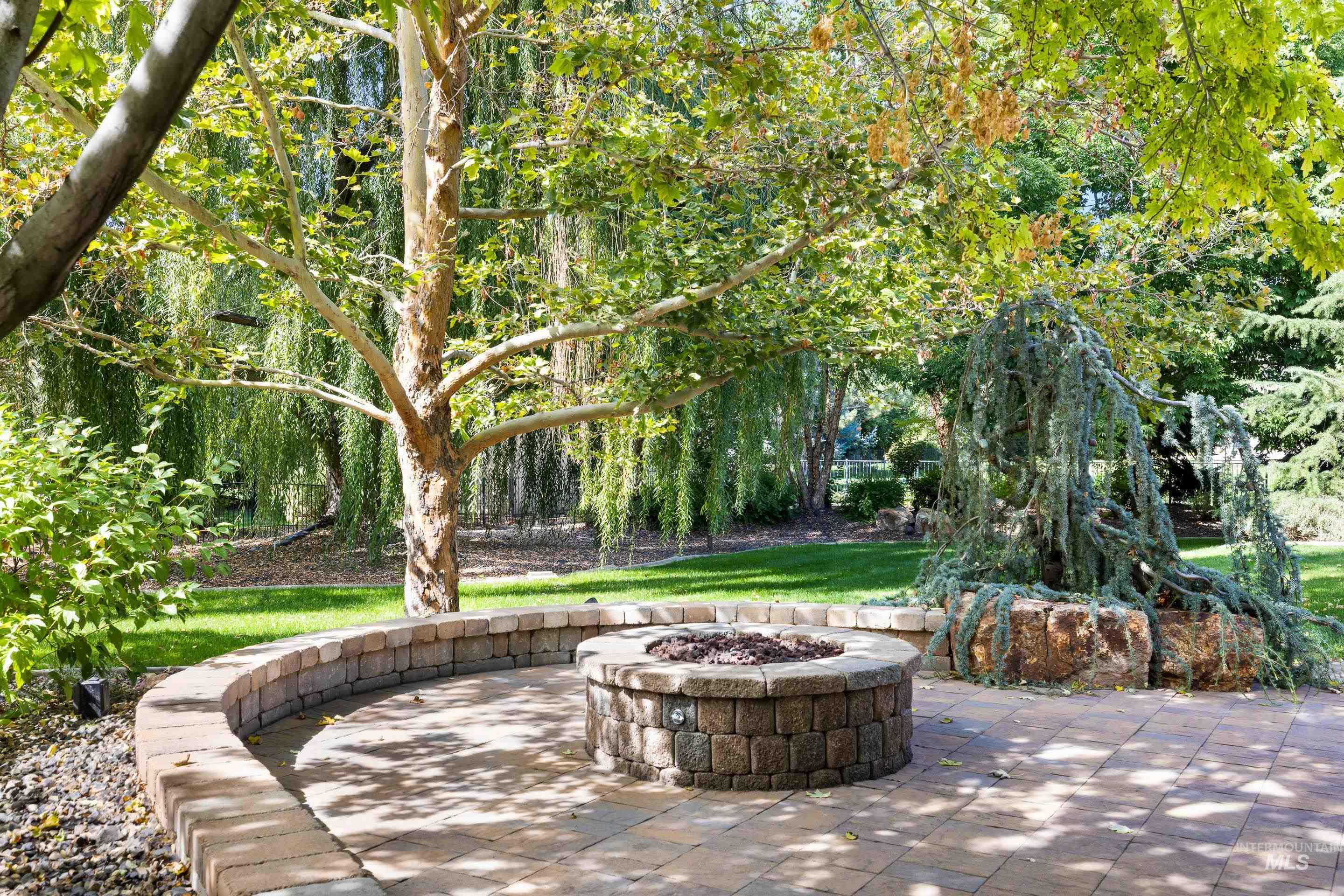 View of patio with a fire pit and a forest view