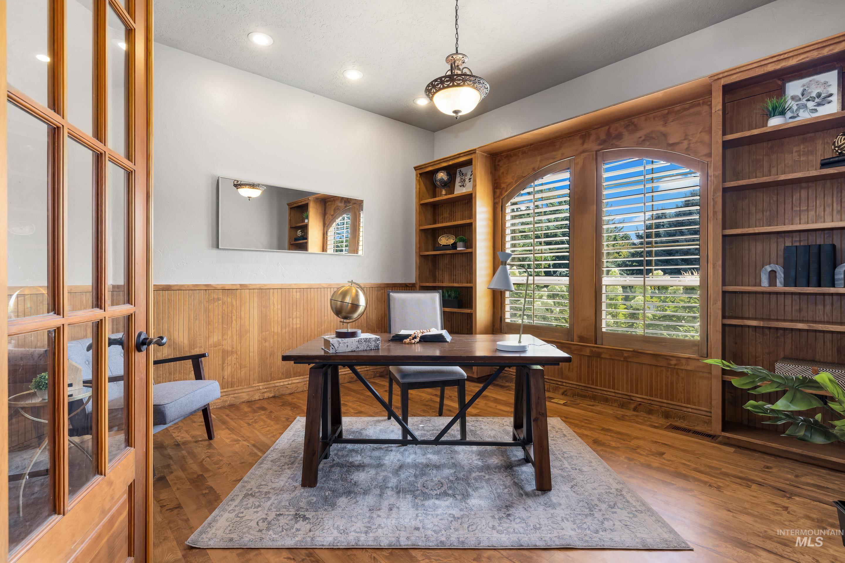 Home office featuring wooden walls, a wainscoted wall, wood finished floors, and recessed lighting