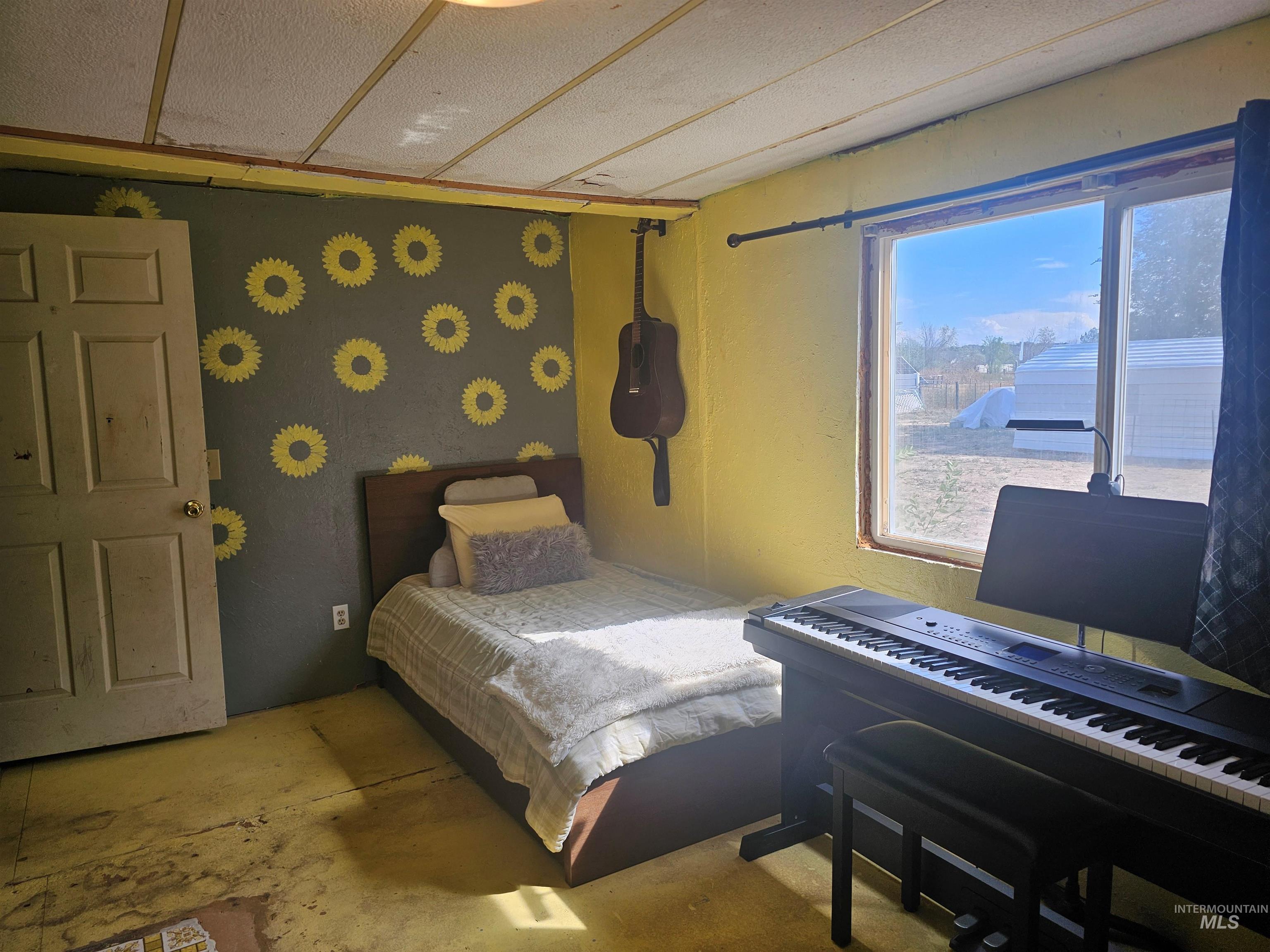 Bedroom with unfinished concrete flooring